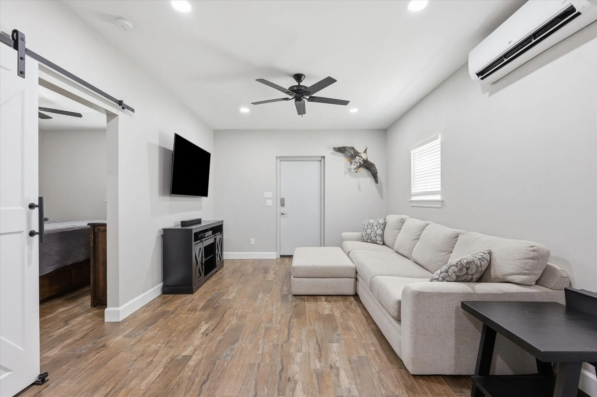 Spacious living area featuring wood-finish flooring, recessed lighting, and a ceiling fan