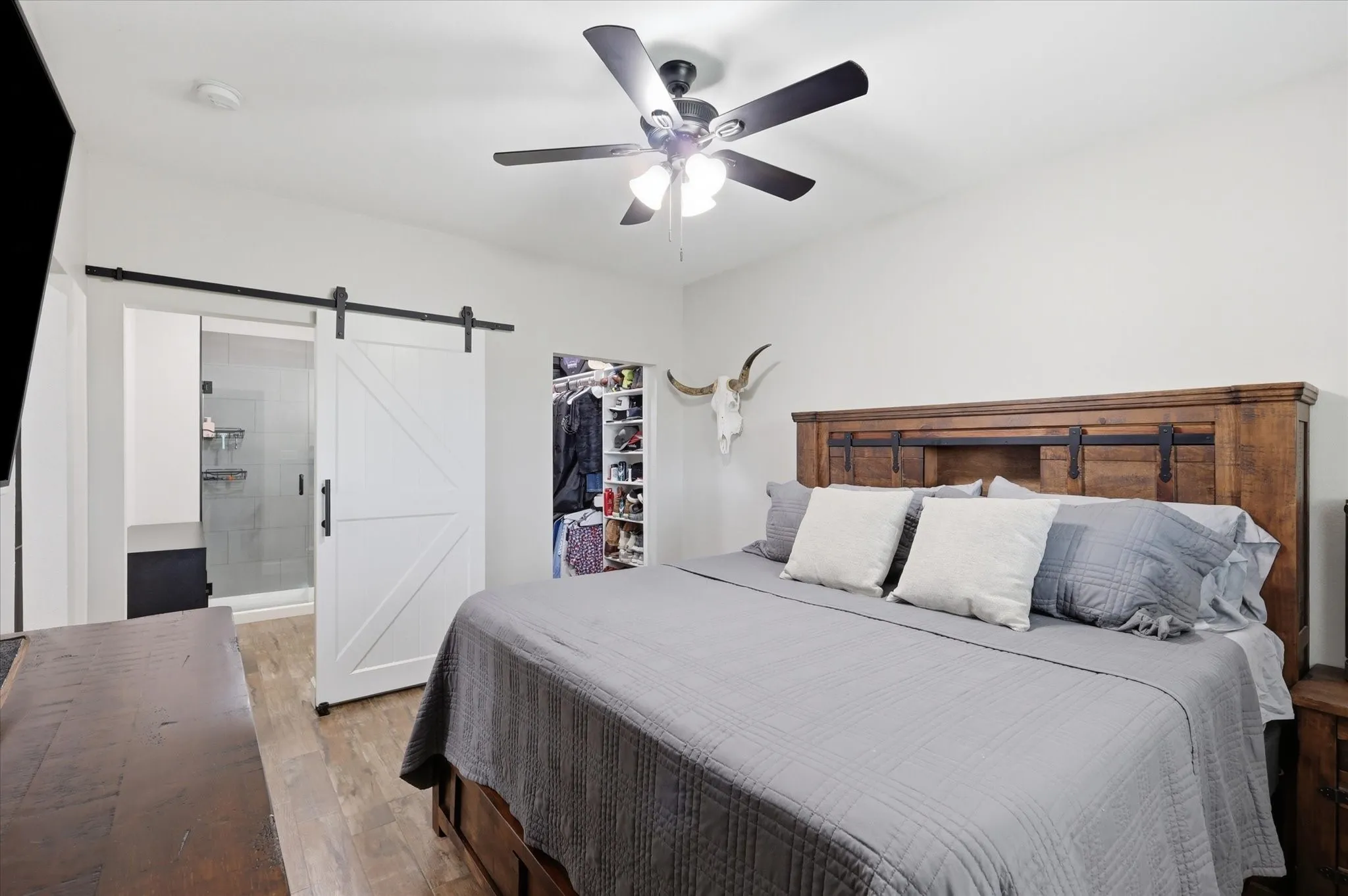 Bedroom featuring wood-finish flooring and a ceiling fan with integrated lighting