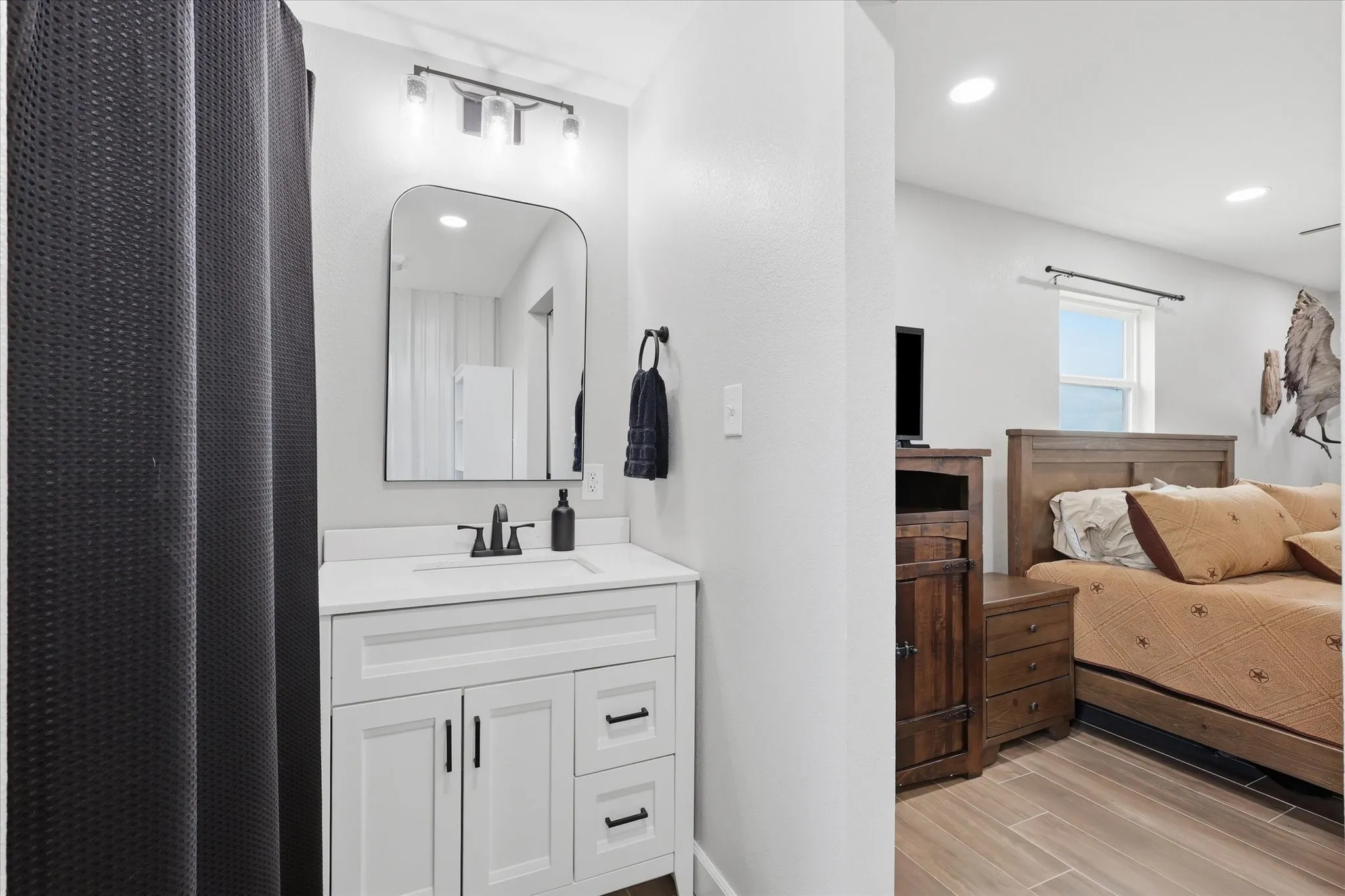 Bathroom vanity featuring a white countertop, undermount sink, and matte black faucet
