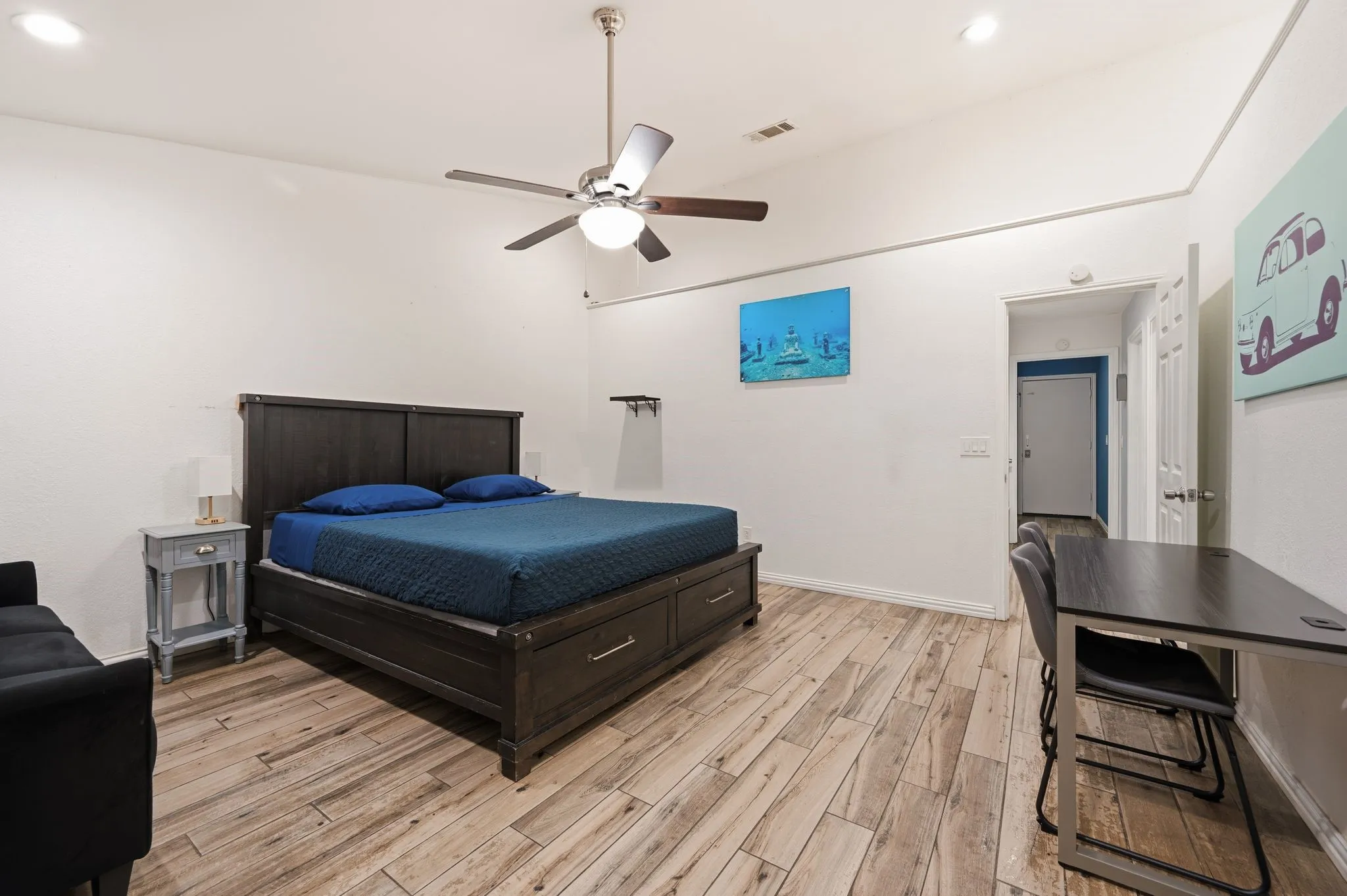 Spacious room featuring wood-finish flooring, a vaulted ceiling with a ceiling fan, and recessed lighting
