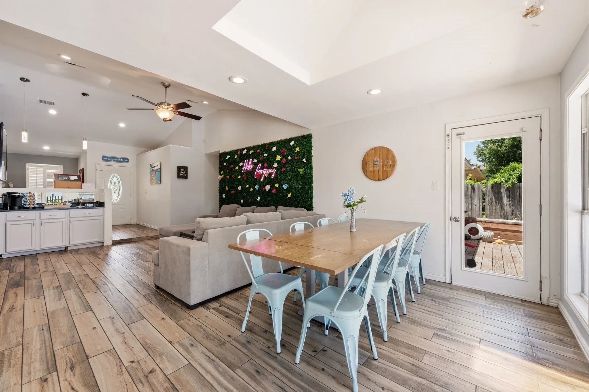 Open-concept living area featuring wood-finish flooring, vaulted ceilings, recessed lighting, and a ceiling fan