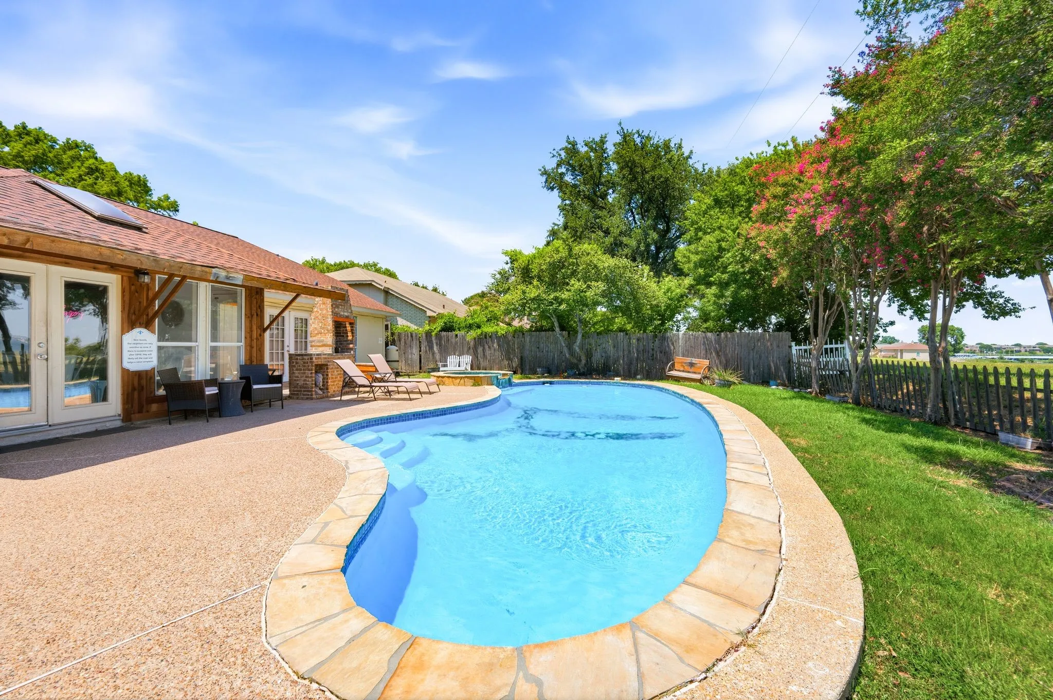 Freeform swimming pool with stone coping and integrated steps