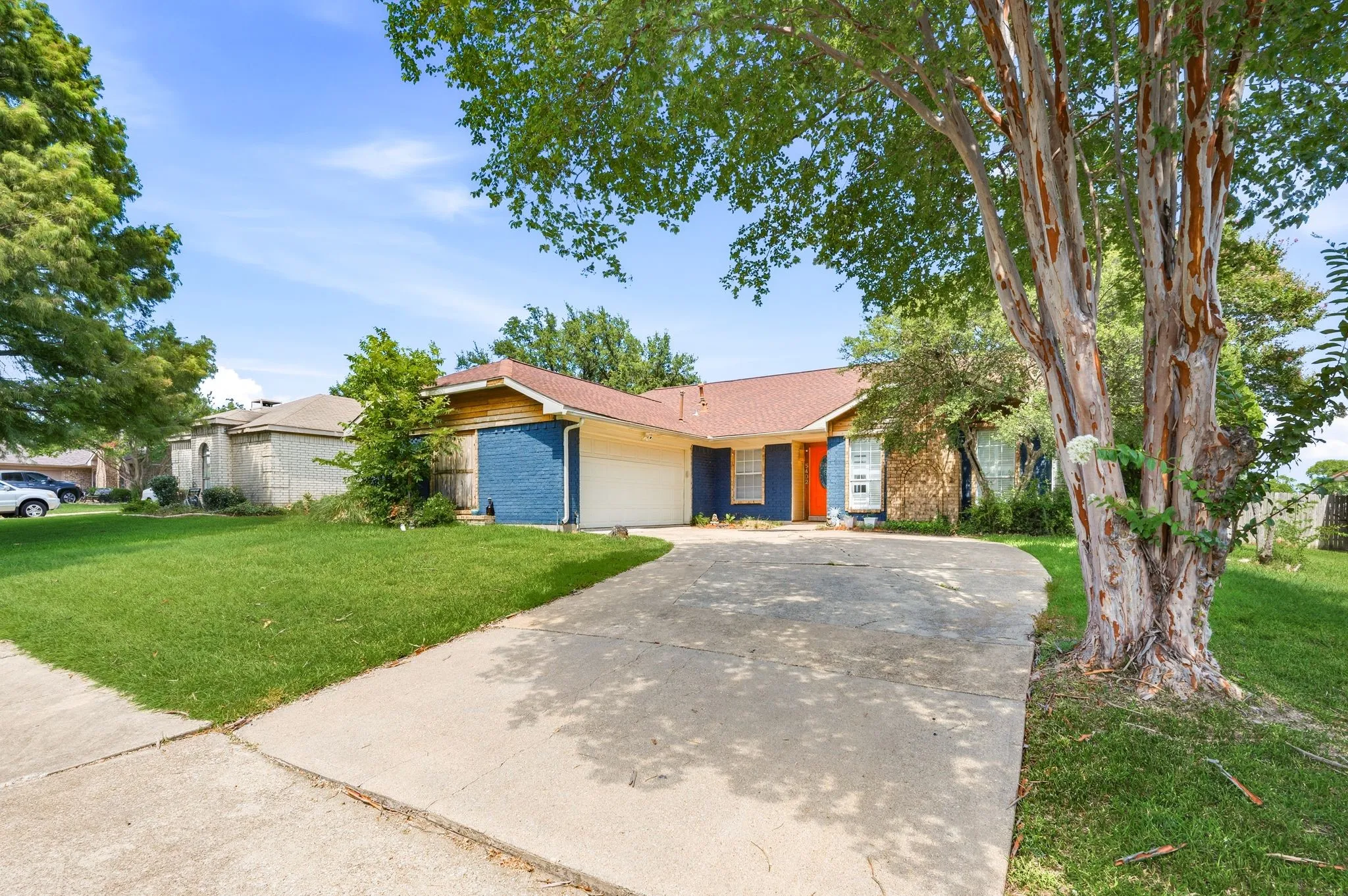 Ranch-style residence featuring a prominent driveway and a substantial front lawn