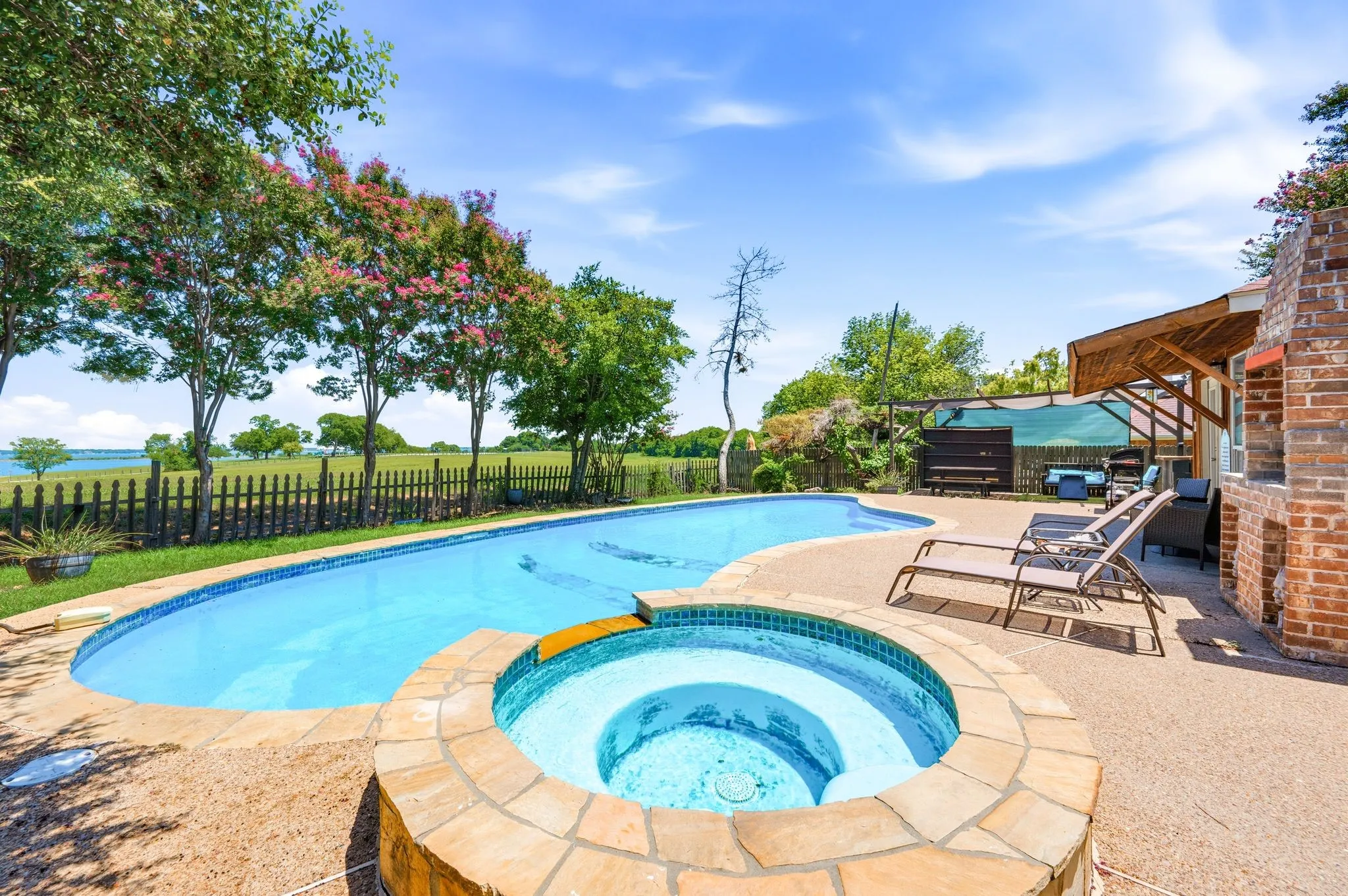 Outdoor oasis featuring a lagoon-style pool and integrated spa