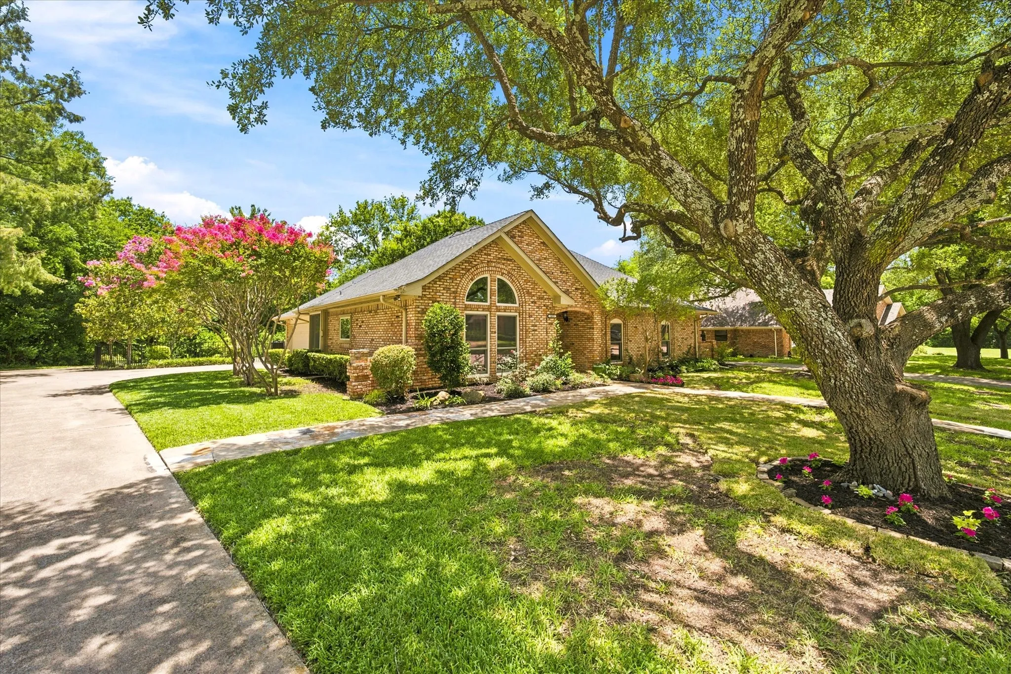 Brick exterior residence featuring an arched window entry and a gabled roof