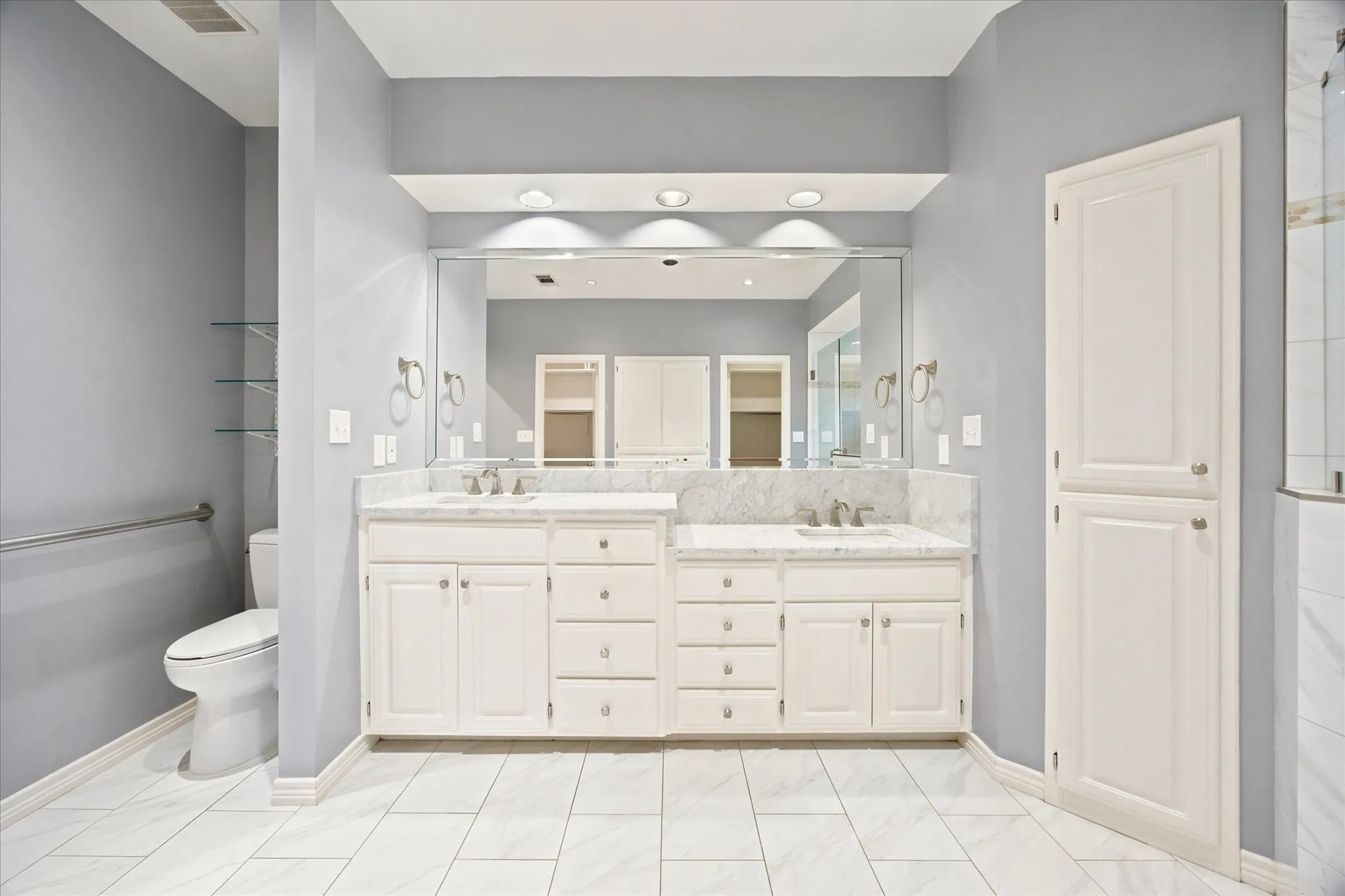 Dual vanity with white cabinetry, stone countertops, and integrated sinks