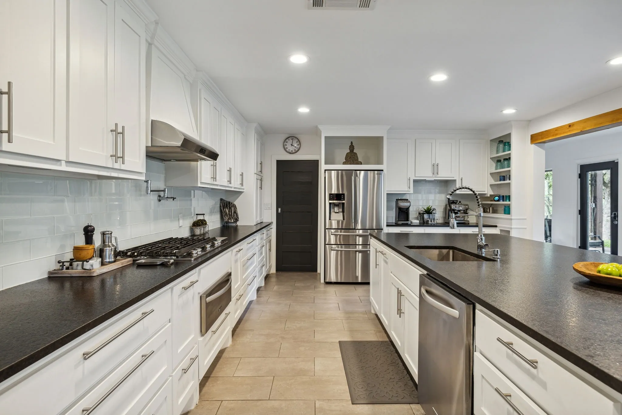 Kitchen featuring appliances with stainless steel finishes, white cabinetry, and leathered granite countertops