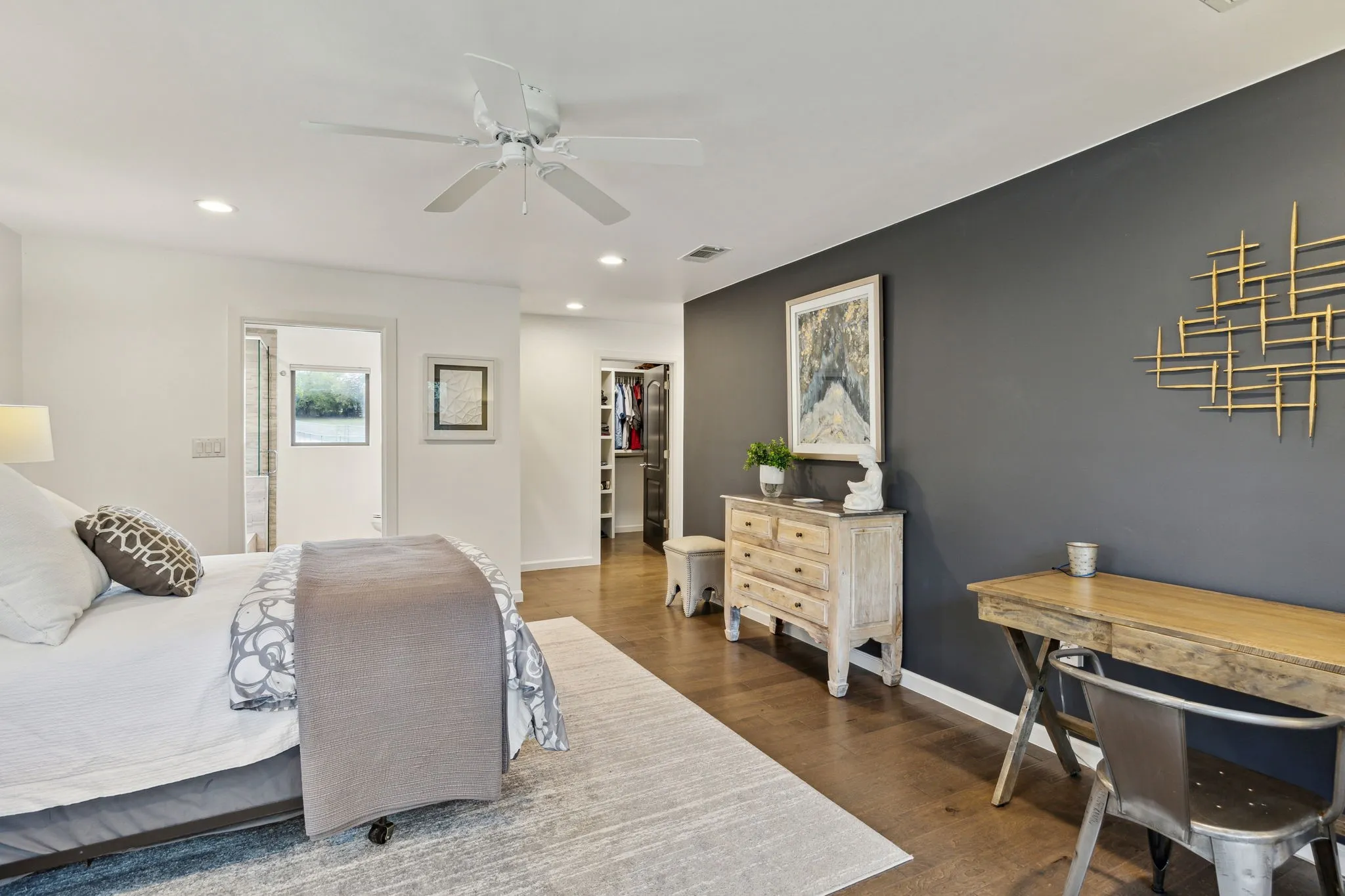 Bedroom featuring a custome walk-in closet, ceiling fan, a spacious closet, and dark wood-type flooring