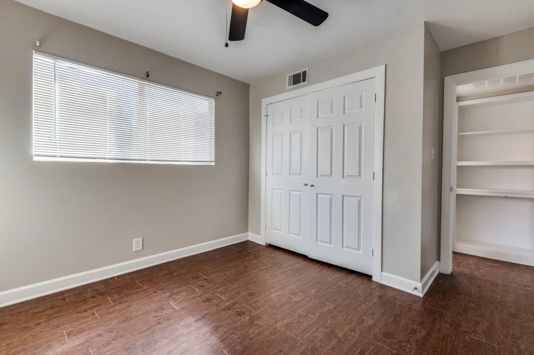 Room with wood-finish flooring, a ceiling fan, and neutral wall tones