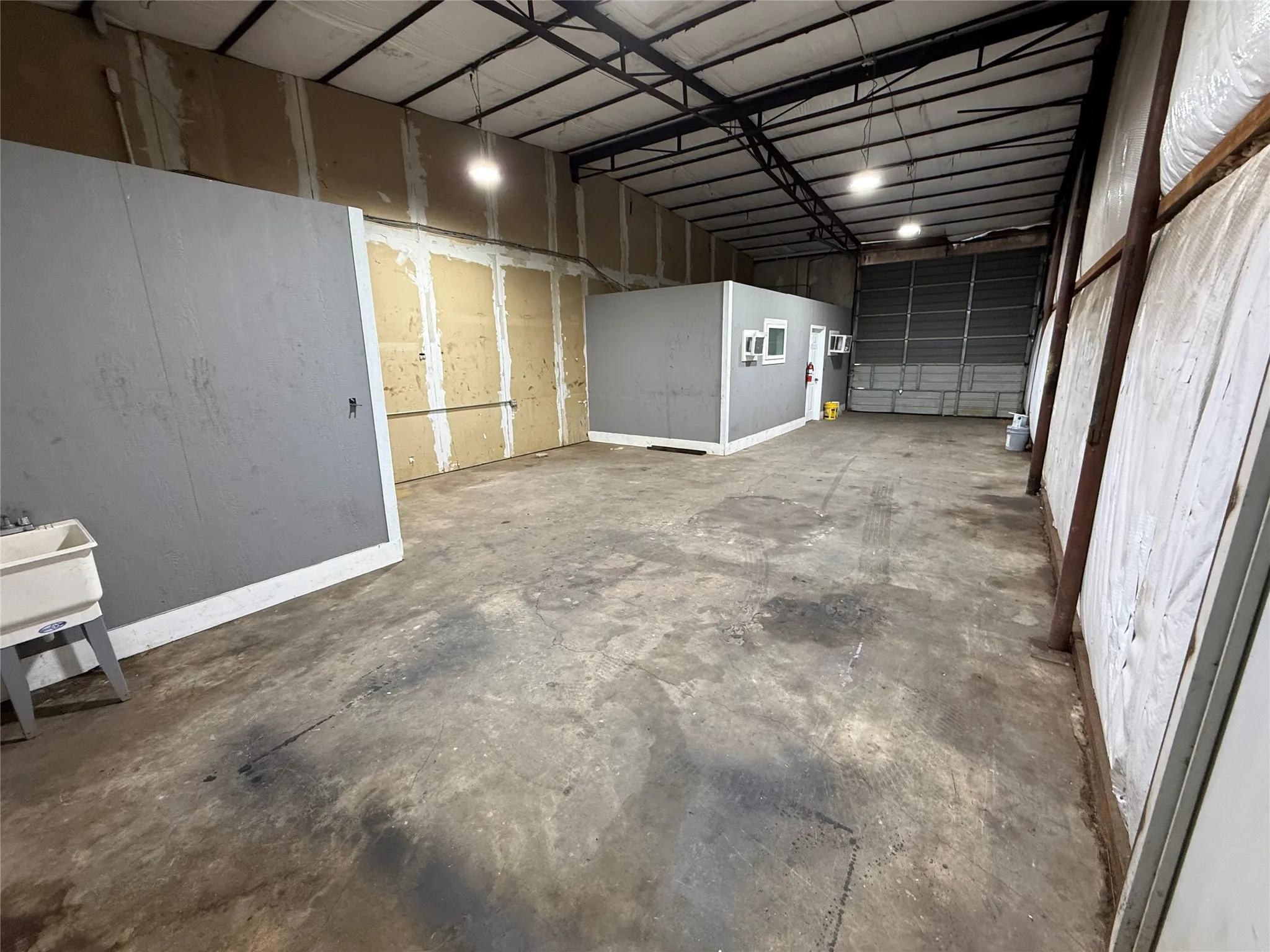 Spacious warehouse interior featuring a concrete floor and exposed beam ceiling