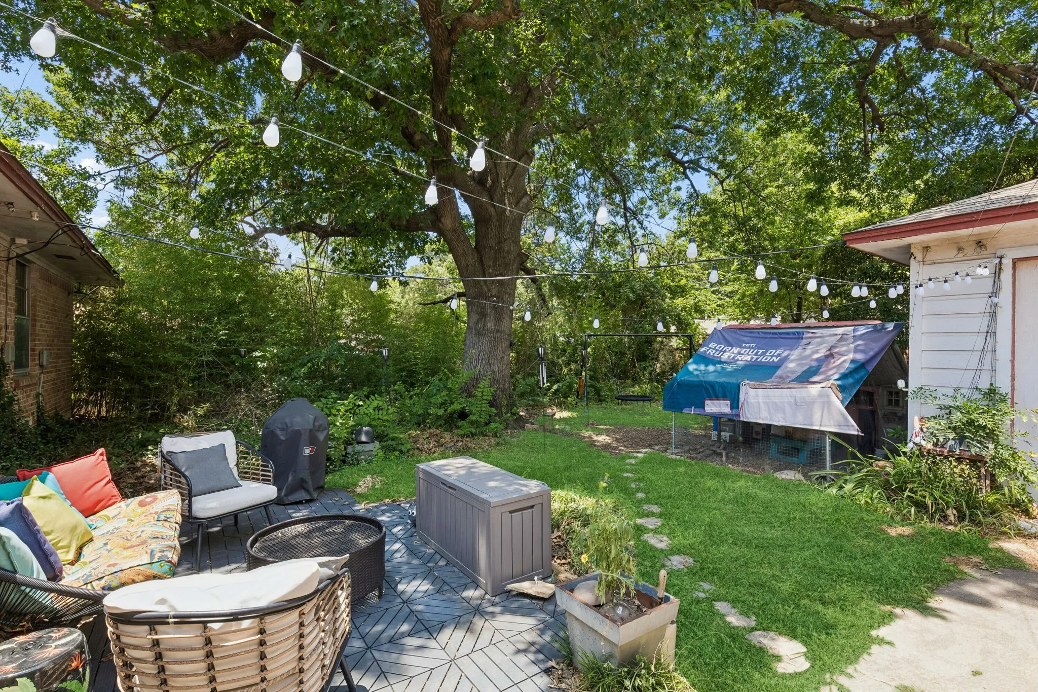 Large backyard with new wood fence along the back and front. There is a two-car detached garage with storage and workbench areas.