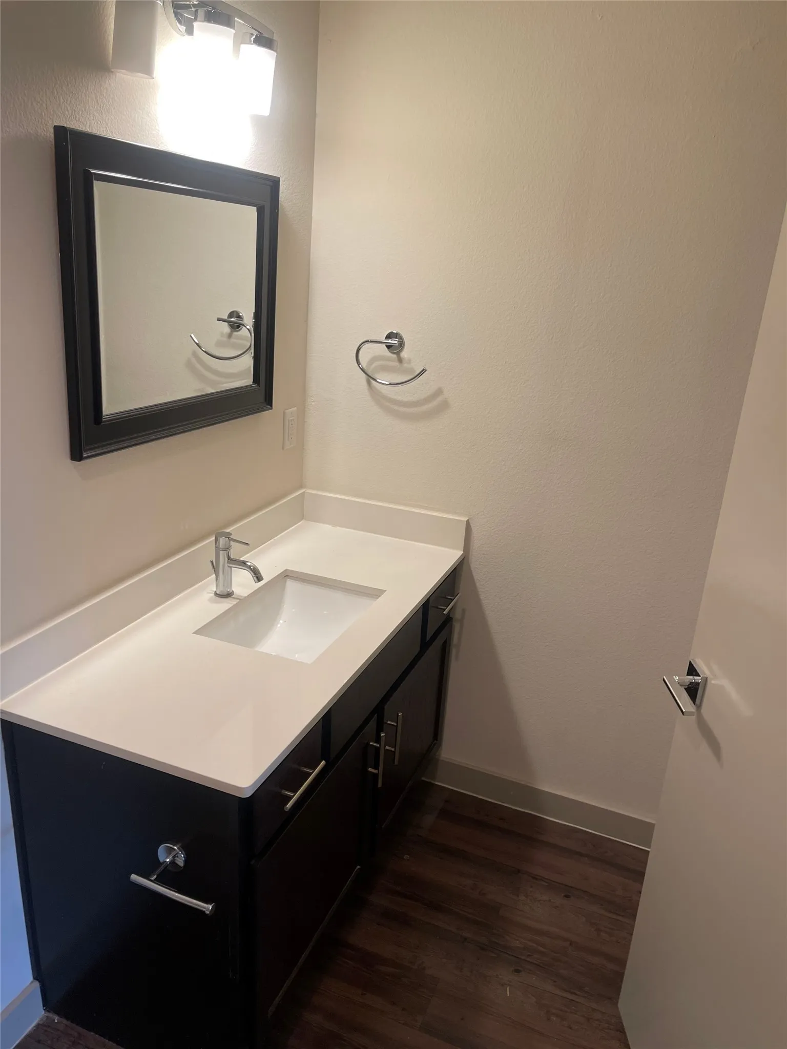 Vanity featuring a white rectangular undermount sink, a chrome faucet, and a light-toned countertop
