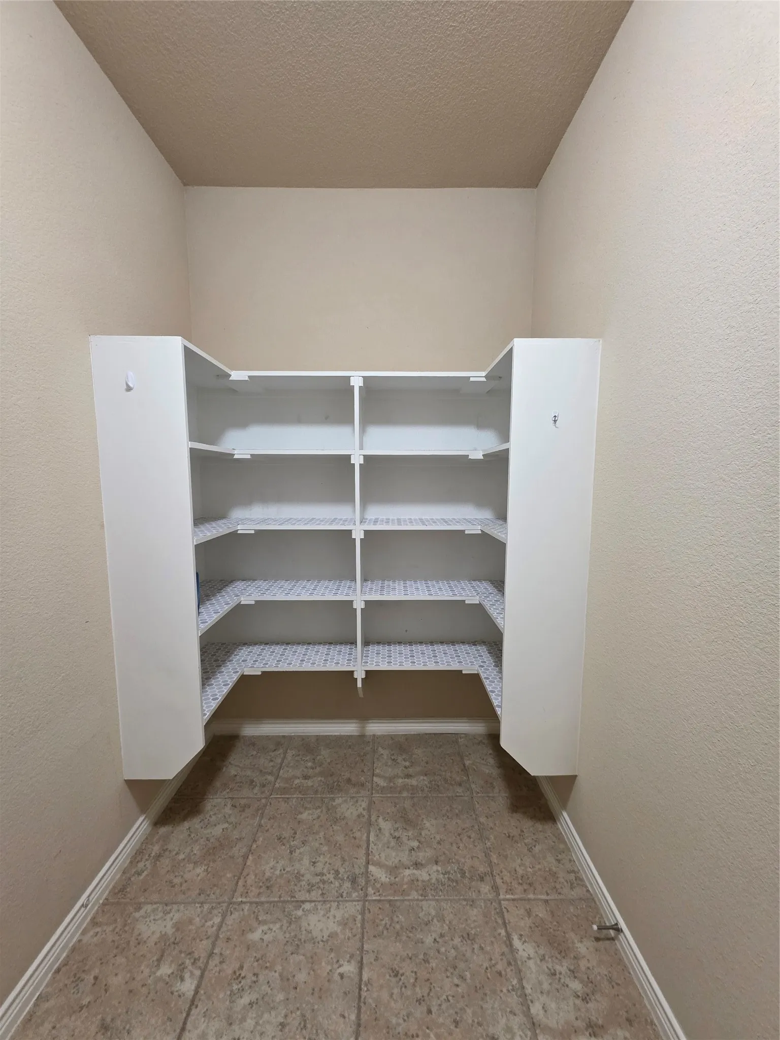 Built-in shelving with multiple storage tiers and a tiled floor