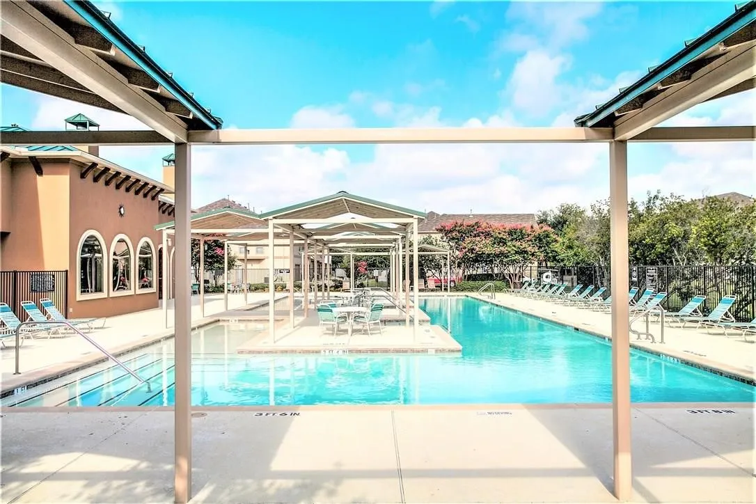 Community swimming pool with surrounding patio space