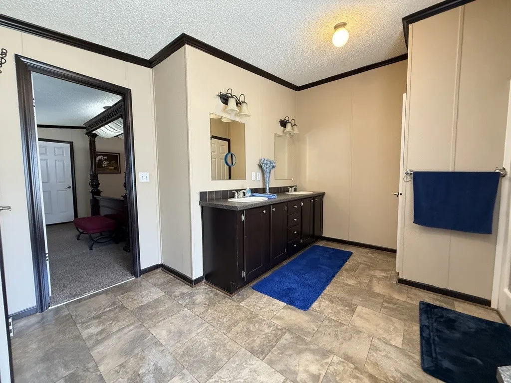 Dual vanity with dark wood-finish cabinetry, integrated sinks, and individual mirrors