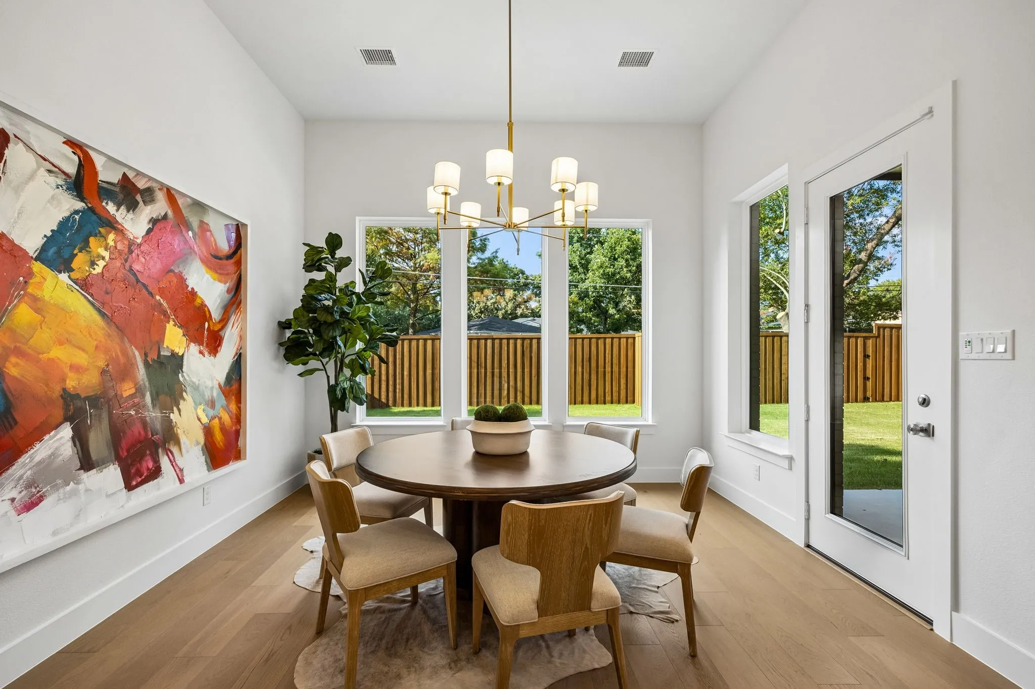Recessed lighting with a modern chandelier, light wood-finish flooring, and a glass-paneled door