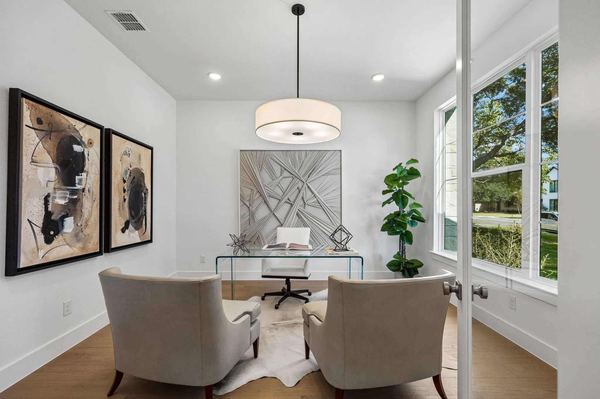 Recessed lighting, a modern drum pendant light, wood-finish flooring, and large windows