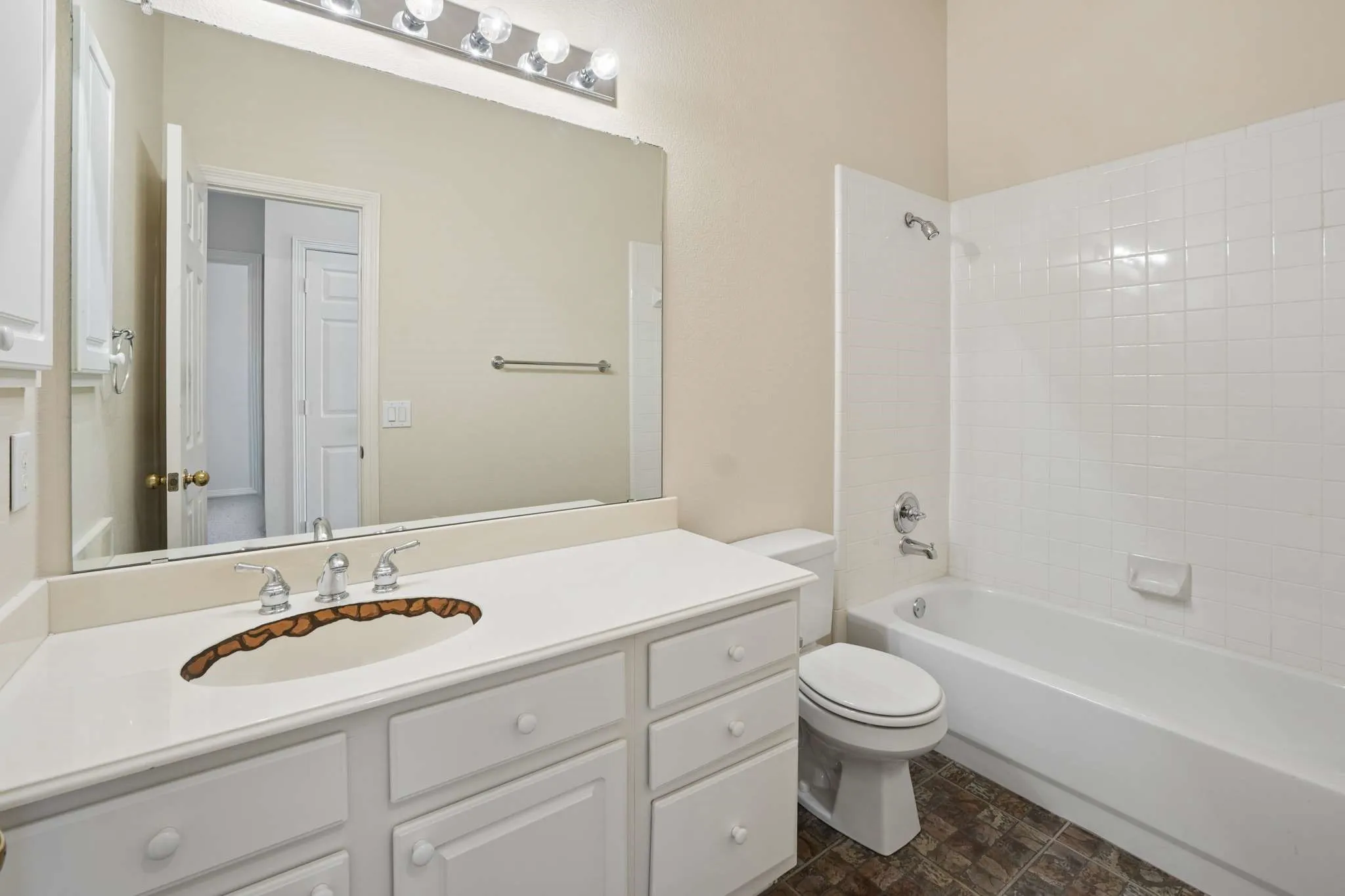 Large secondary bathroom with custom painted stone line trim in sink to go with the stone looking flooring.  (Paint can be removed with paint thinner).