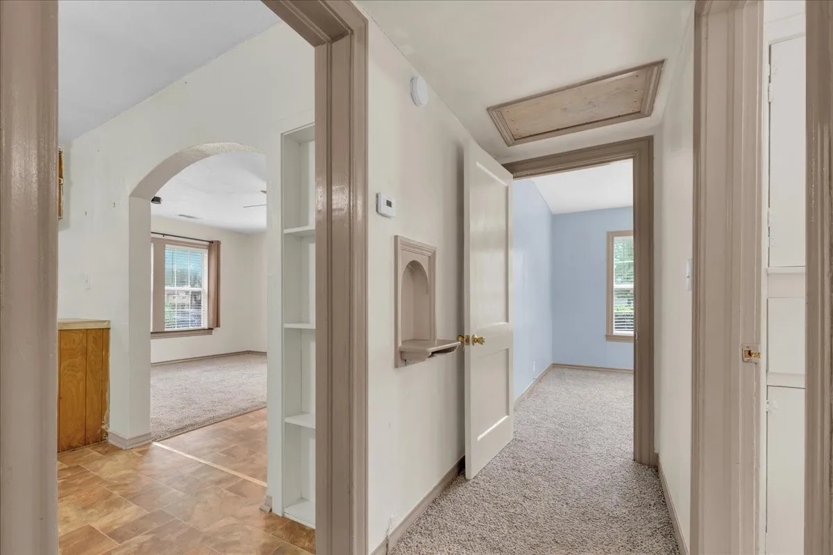 Interior hallway featuring carpeted flooring and an attic access panel
