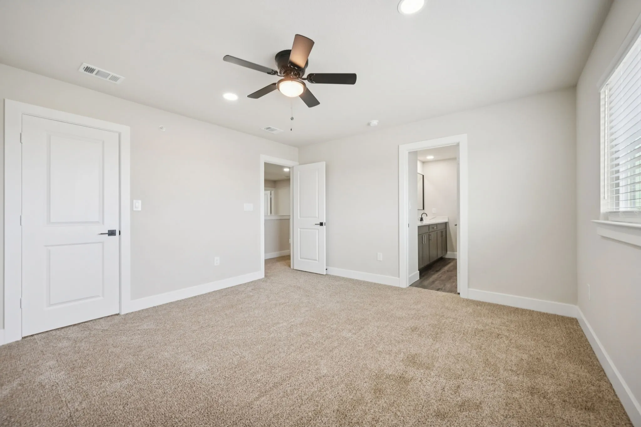Carpeted room with a ceiling fan, recessed lighting, and a window with blinds