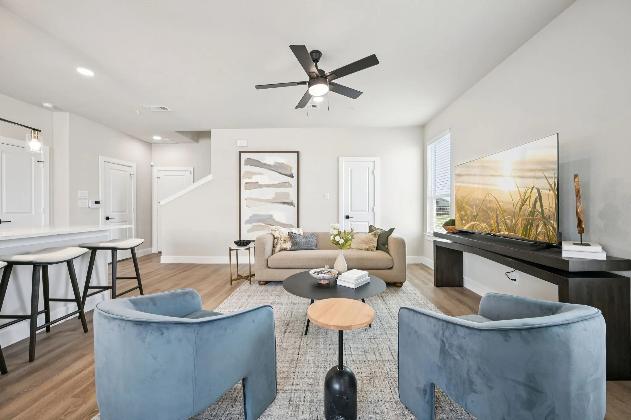 Open-concept living area featuring wood-finish flooring, recessed lighting, and a contemporary ceiling fan