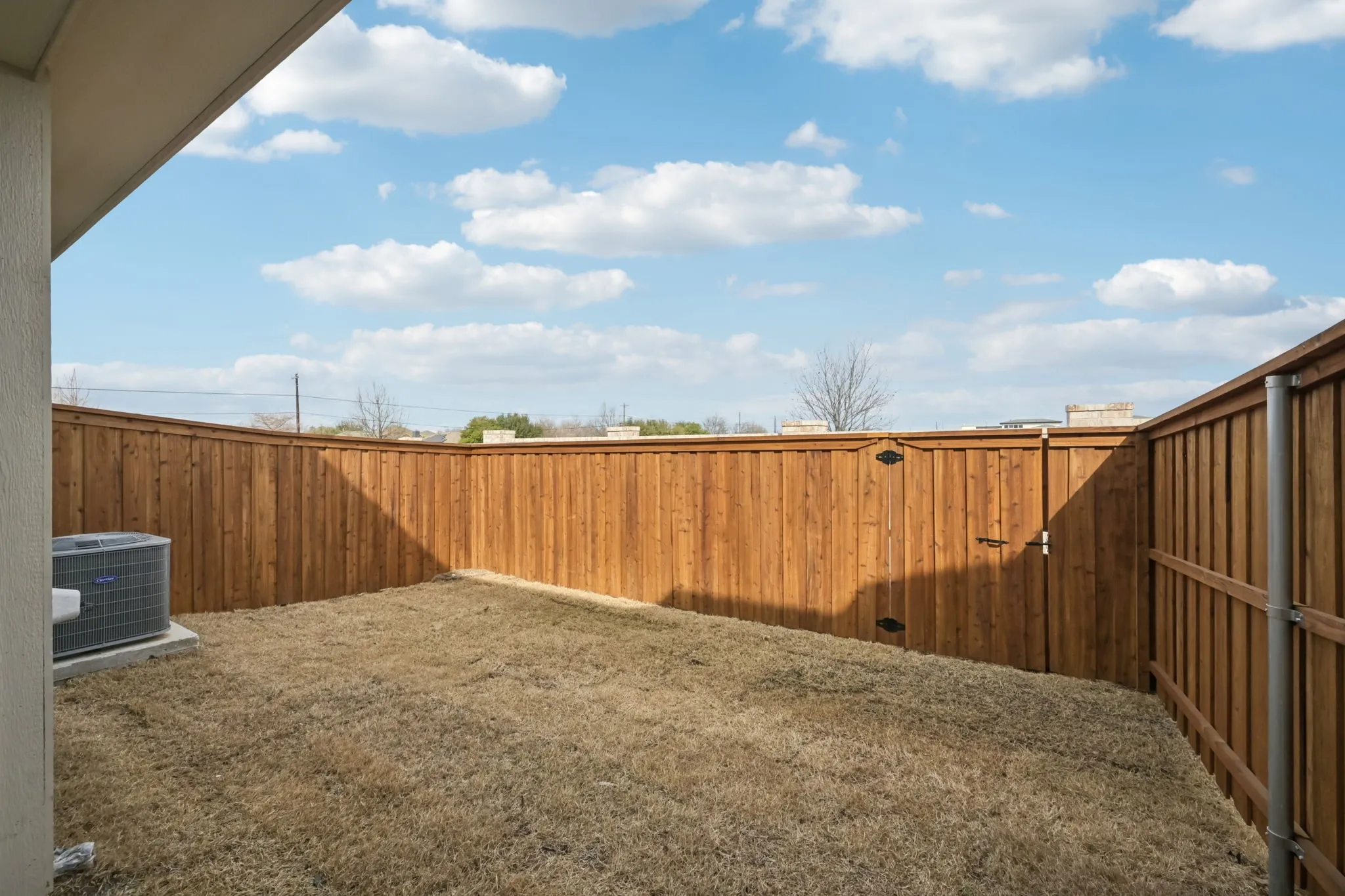 Enclosed backyard featuring natural wood fencing and a grassy area