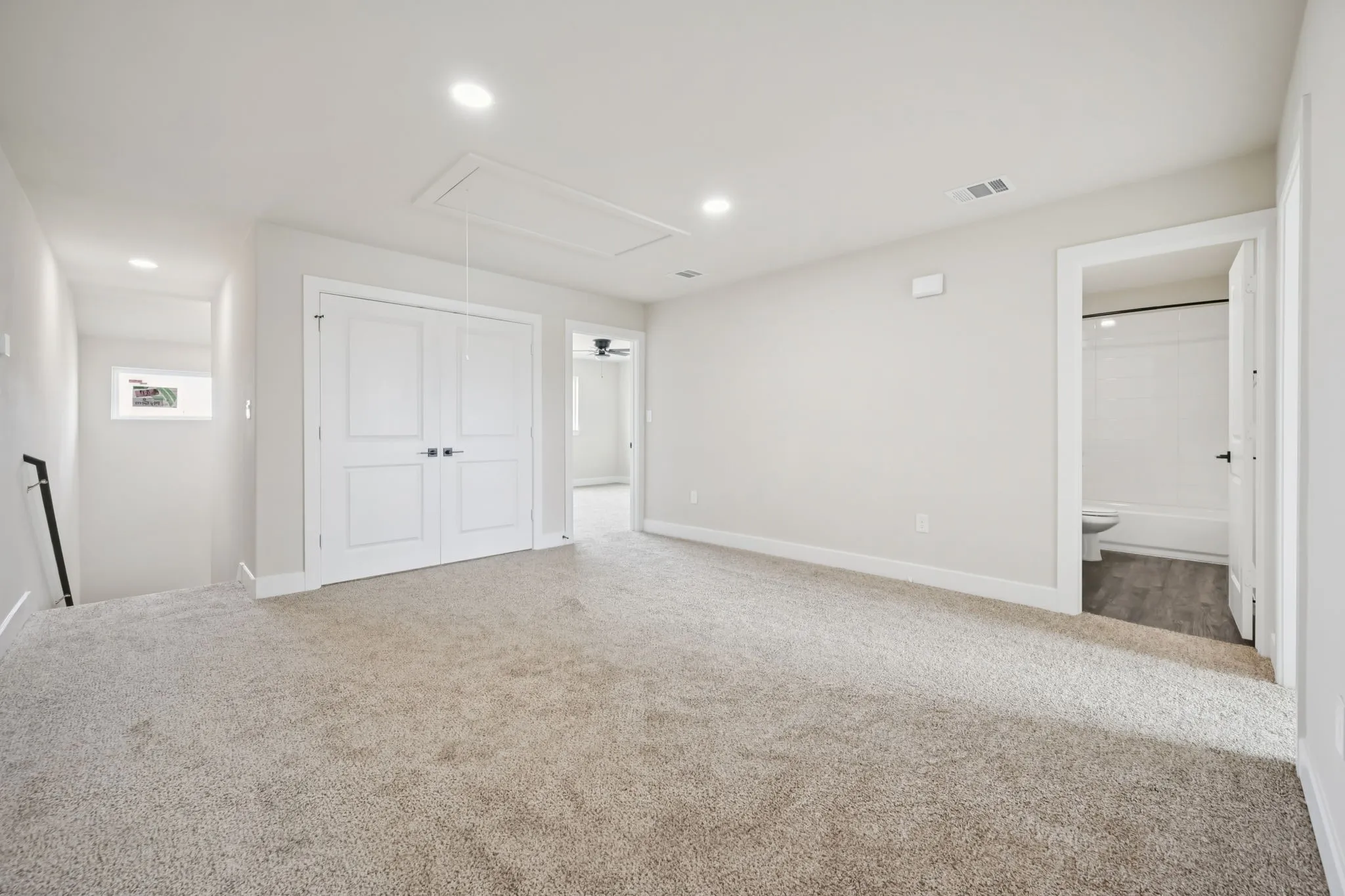 Carpeted room with recessed lighting and neutral wall tones