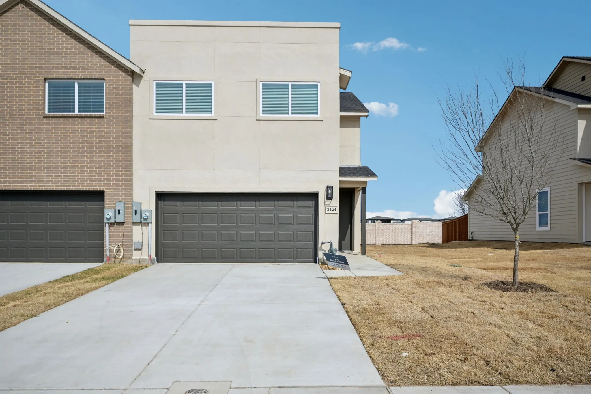 Modern stucco exterior featuring a flat roofline and a panel garage door