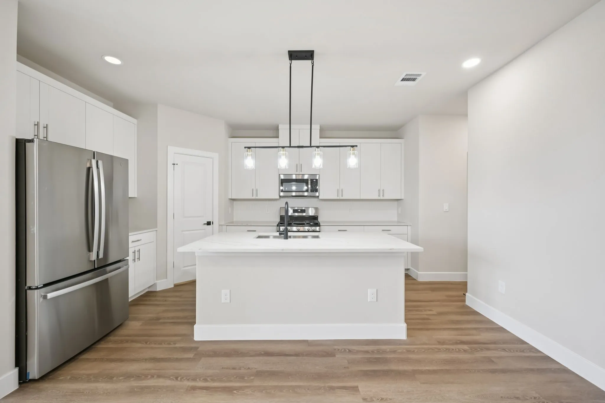 Modern kitchen with a central island featuring a sink and a black faucet