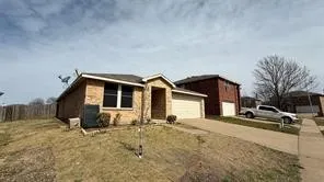Brick facade with an attached two-car garage, concrete driveway, and covered entry