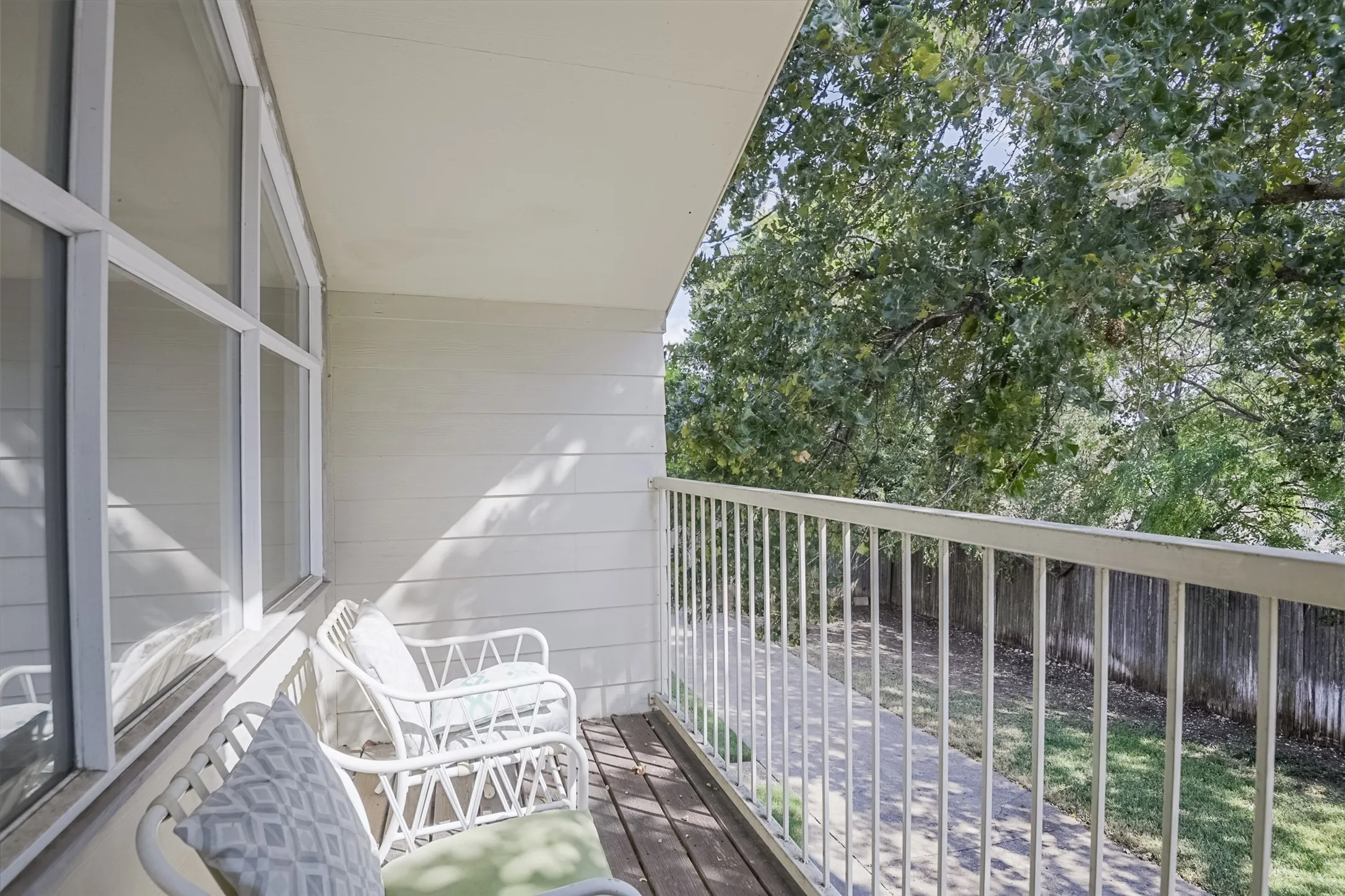 Balcony with wood-finish flooring and white metal railing