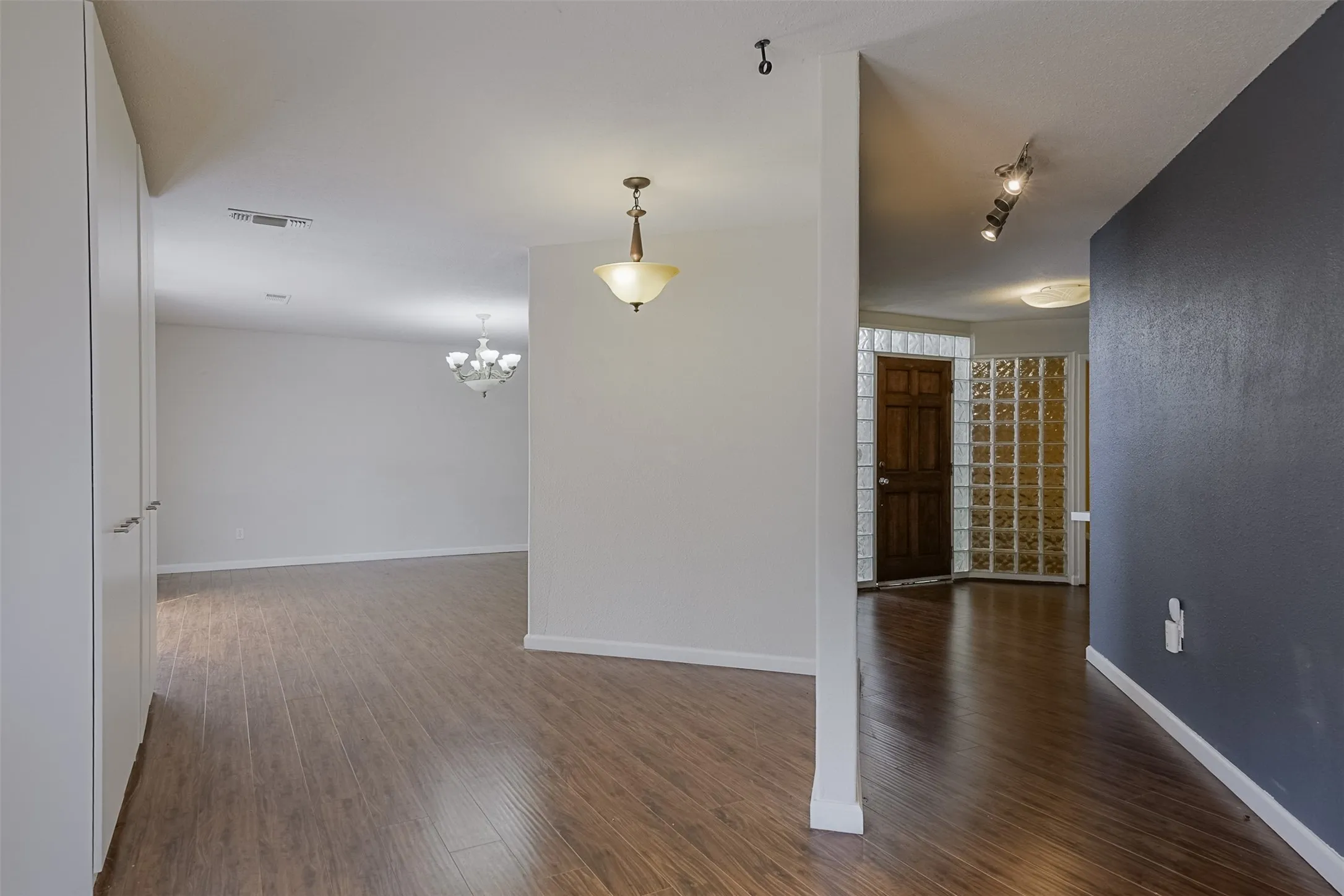 Wood-finish flooring throughout, with a classic chandelier and pendant lighting fixtures