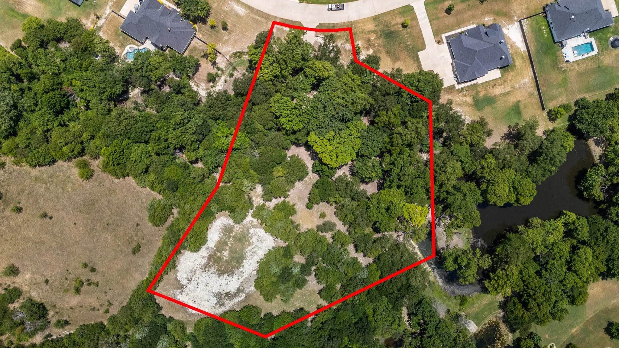 Expansive wooded lot with varied terrain, featuring mature trees and clearings