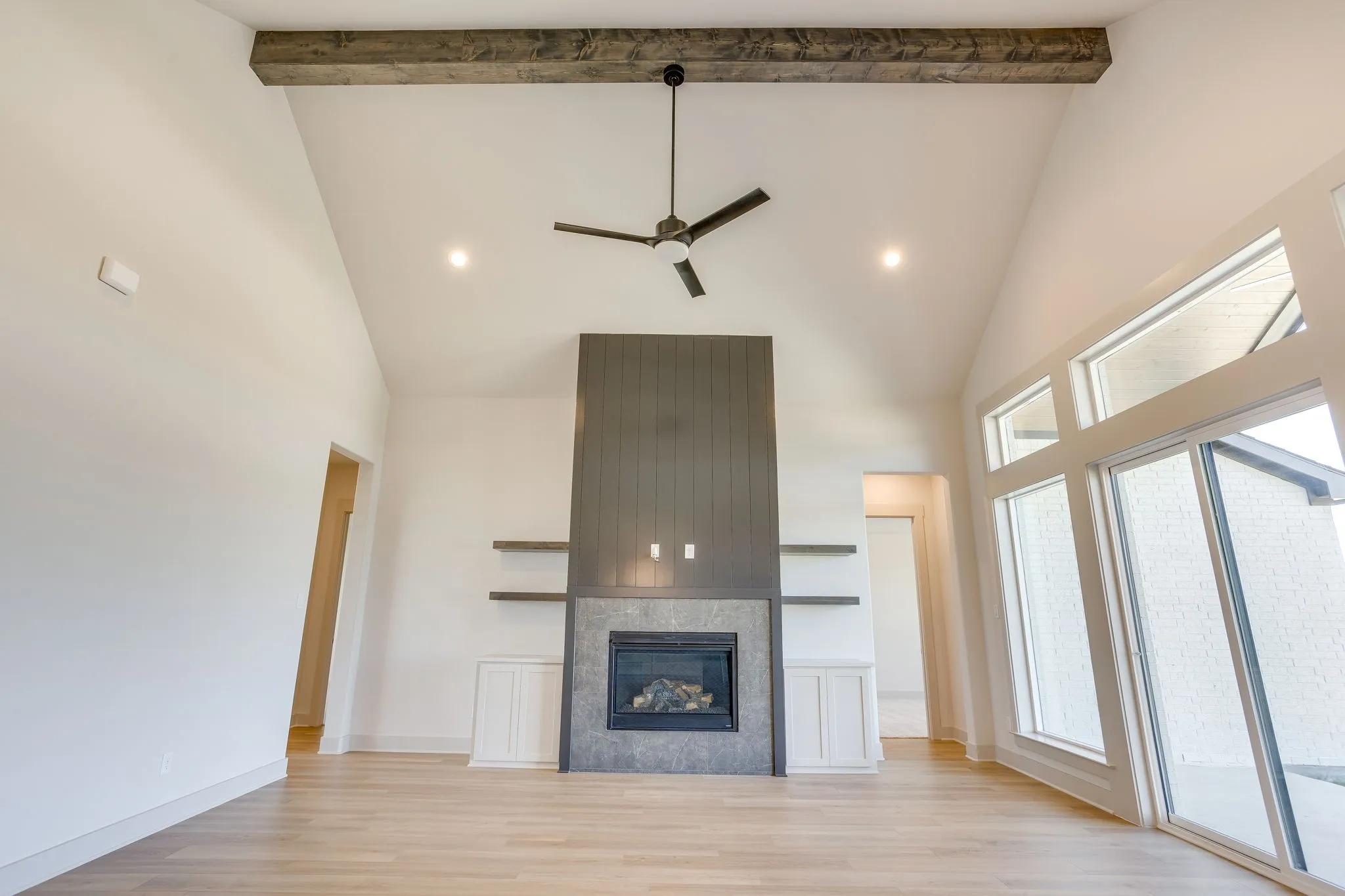 Vaulted ceiling with a wood-finish beam and ceiling fan