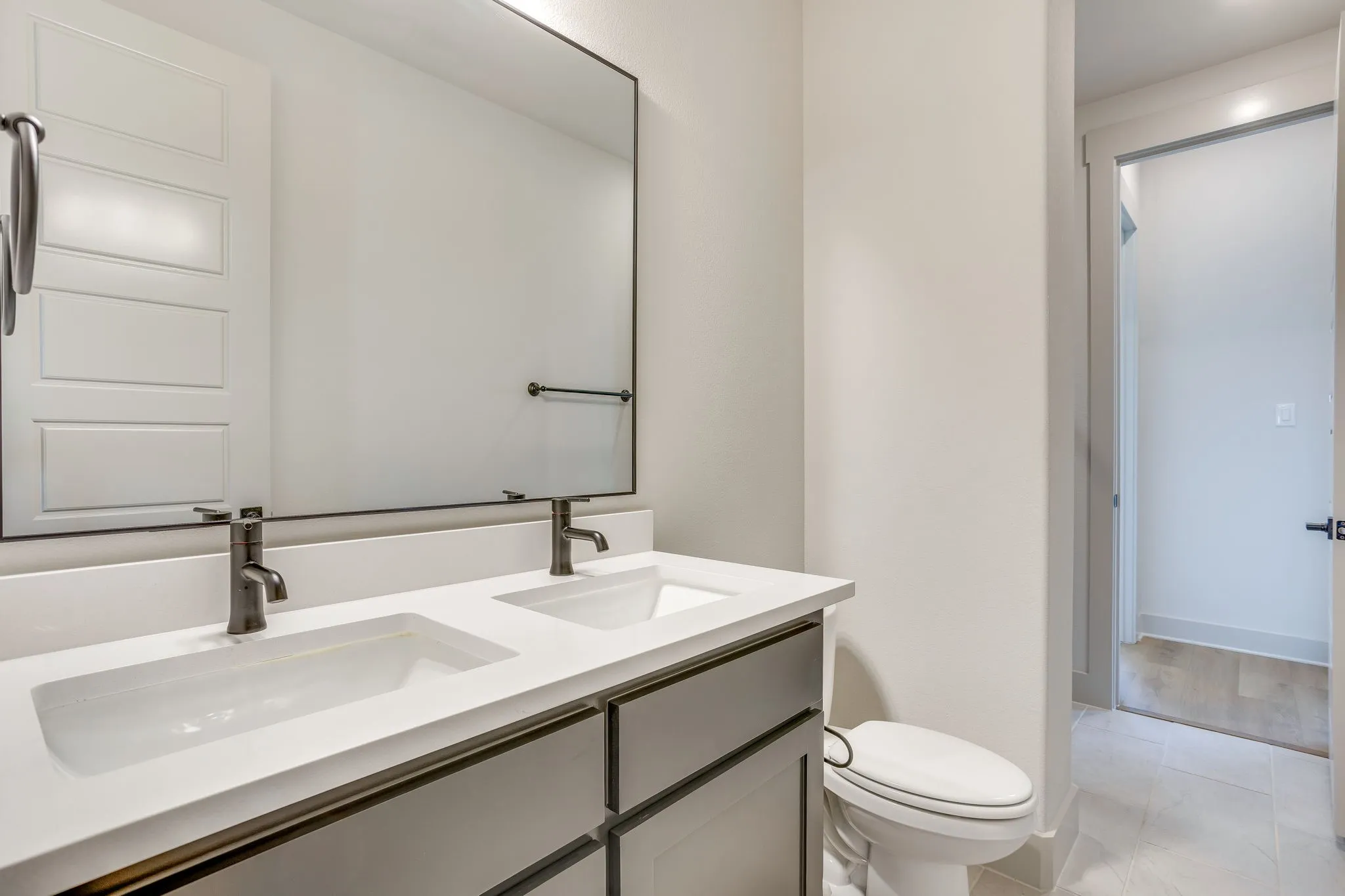 Dual vanity with integrated white rectangular sinks and gray base cabinetry