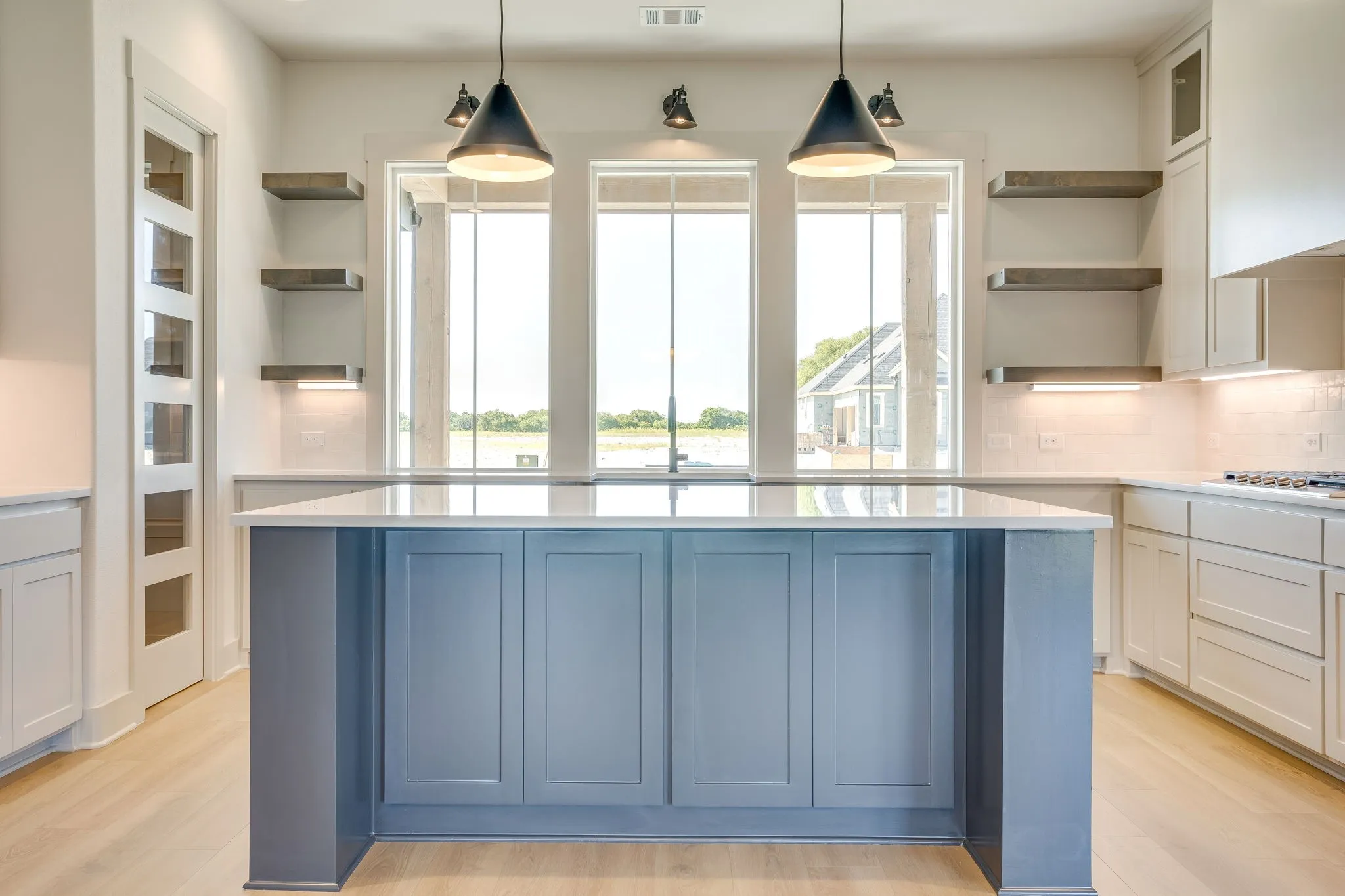 Central kitchen island featuring blue-painted cabinetry and a light-toned countertop