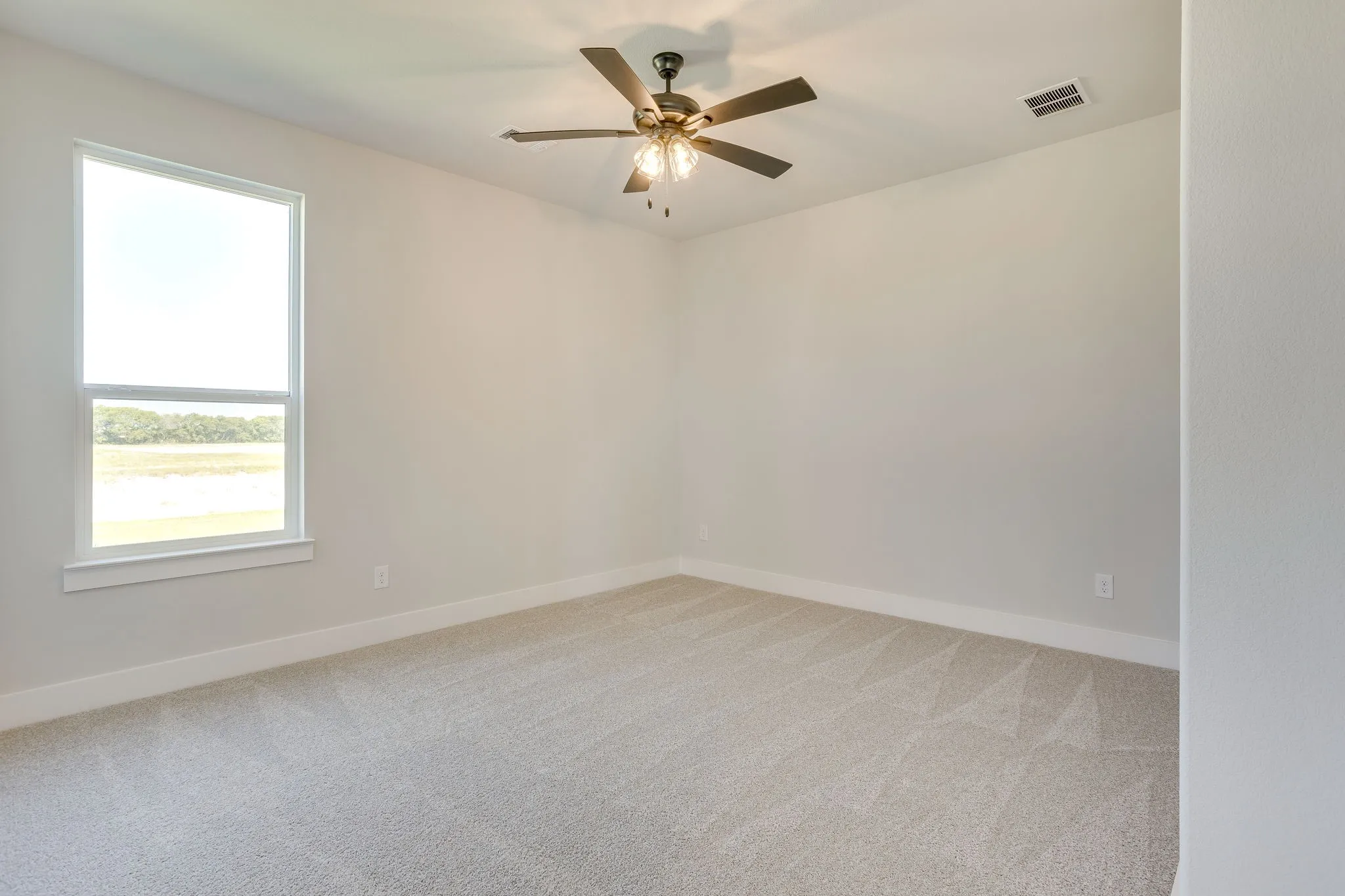 Bright interior space featuring light gray wall paint and a single window with white trim