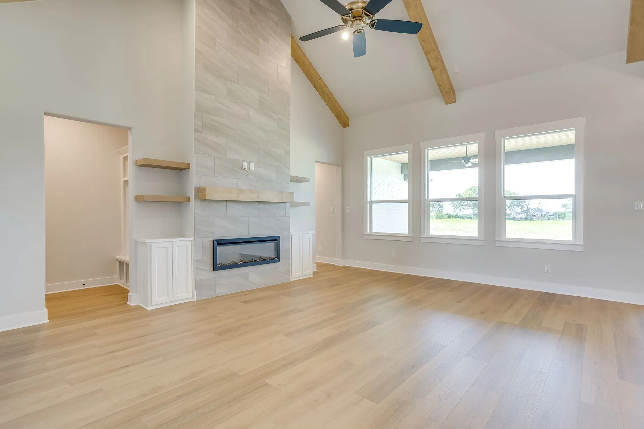 Vaulted ceiling with exposed wood beams and a ceiling fan