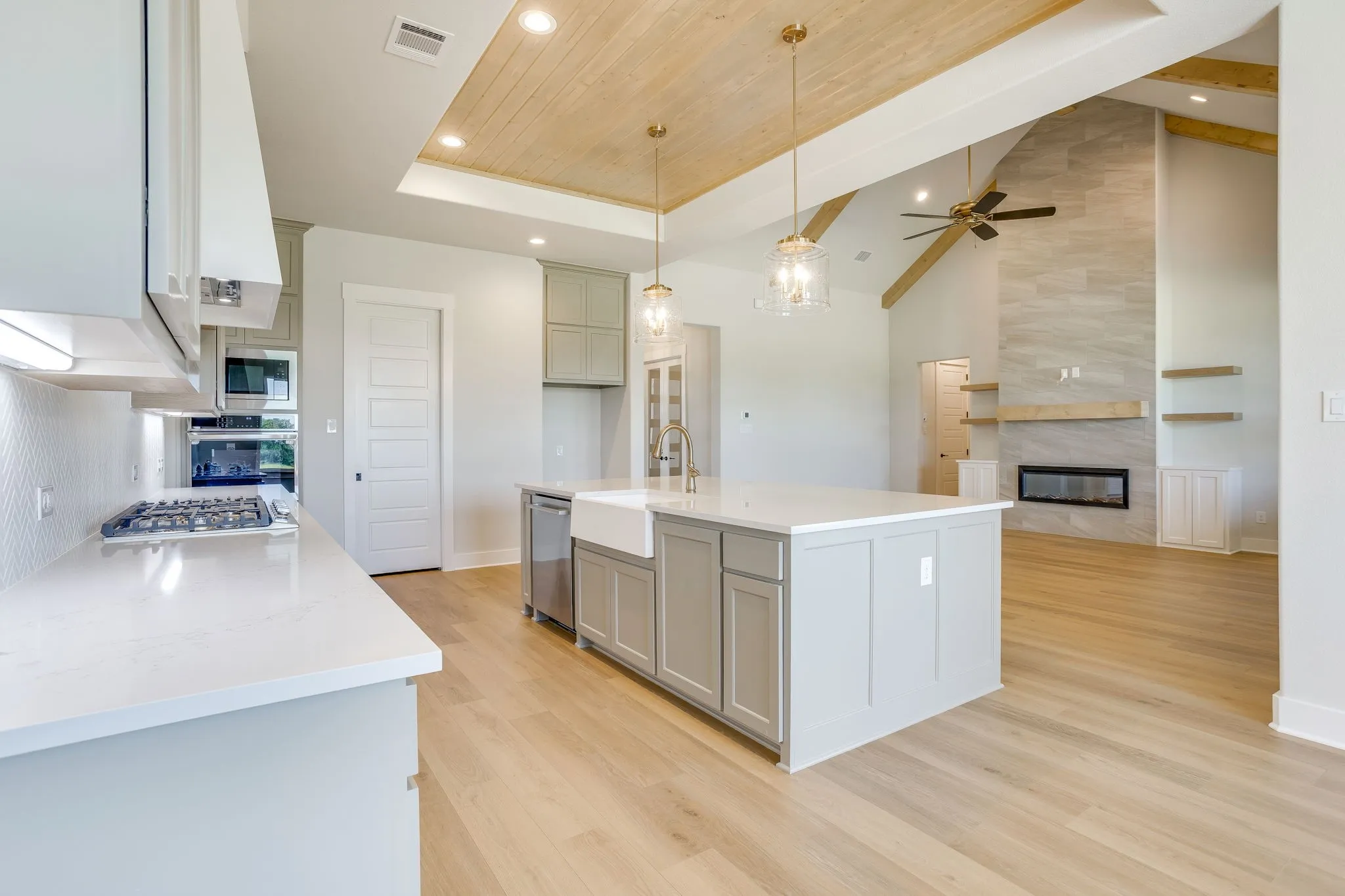 Spacious kitchen with a large island, farm sink, gas cooktop, and built-in appliances