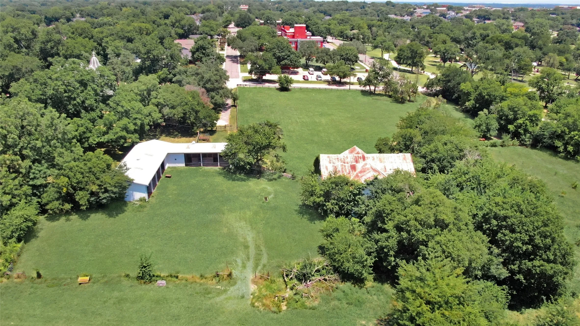 Expansive acreage featuring two distinct structures and lush green space