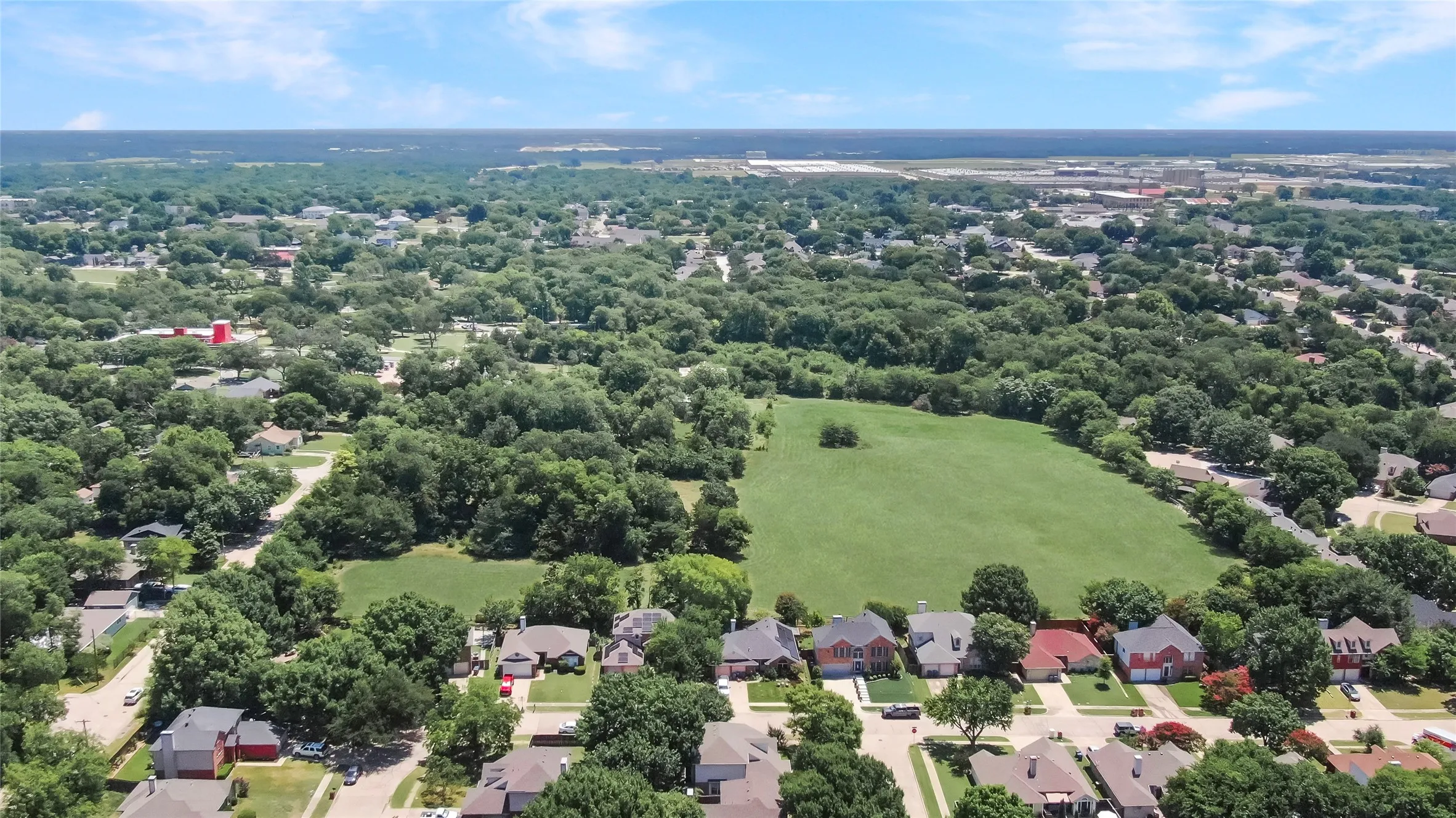 Expansive aerial perspective showcasing a residential development amidst abundant mature trees