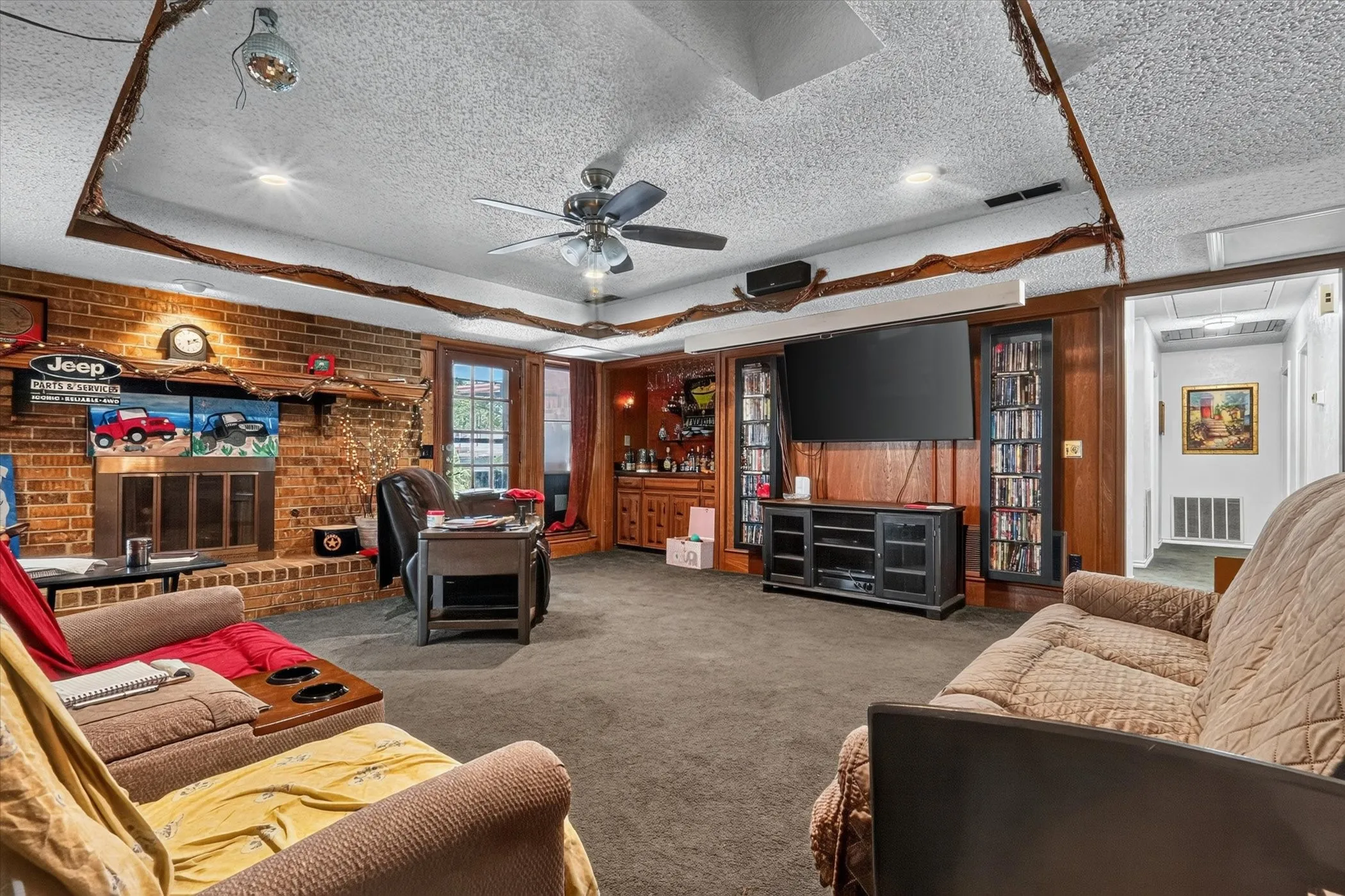 Spacious living area featuring a prominent brick fireplace with a wood mantel