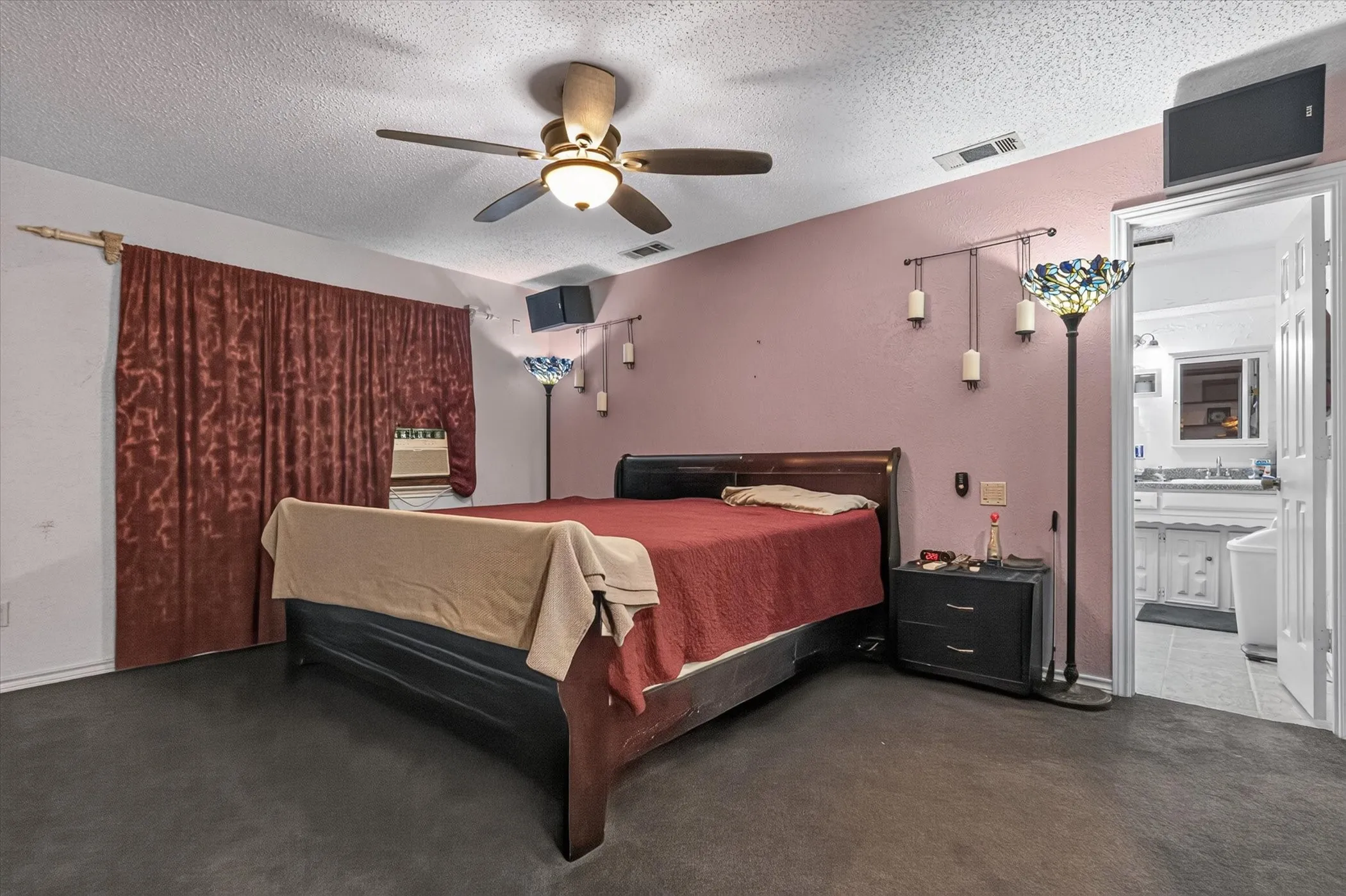 Bedroom featuring ceiling fan with integrated lighting, dark wood-finish bed frame, and carpet flooring