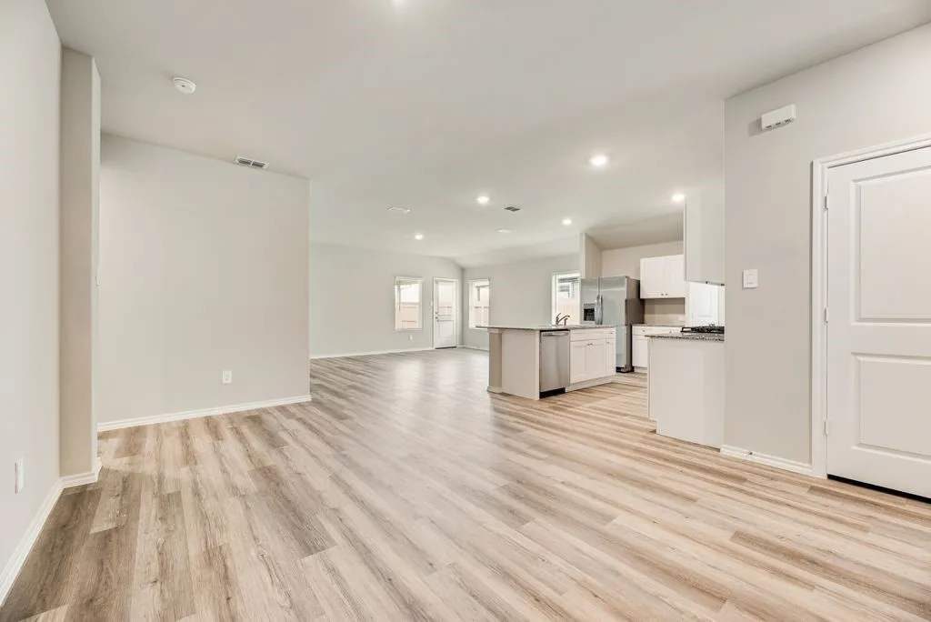 Open-concept living space featuring wood-finish flooring, recessed lighting, and light neutral wall colors