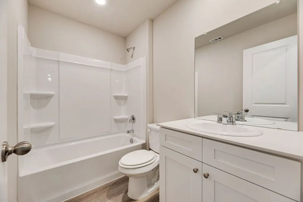 White vanity with an undermount sink, chrome faucet, and expansive mirror
