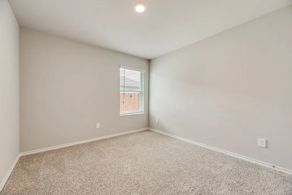 Carpeted room featuring a single window with blinds, a recessed ceiling light, and light-toned wall paint