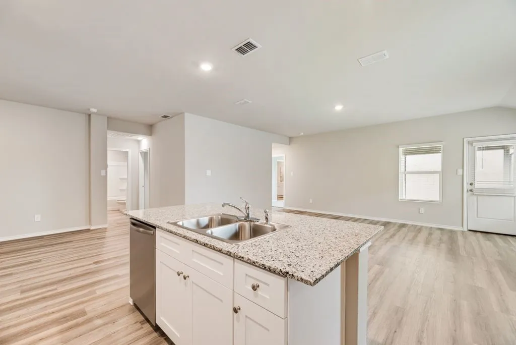 Kitchen island with a double basin stainless steel sink and a granite-style countertop