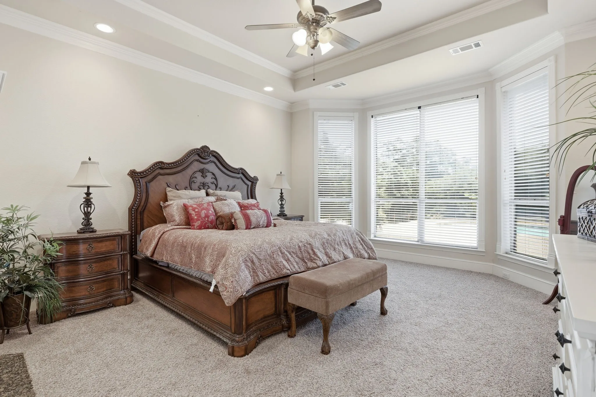 Carpeted bedroom with a bay window featuring multiple large windows