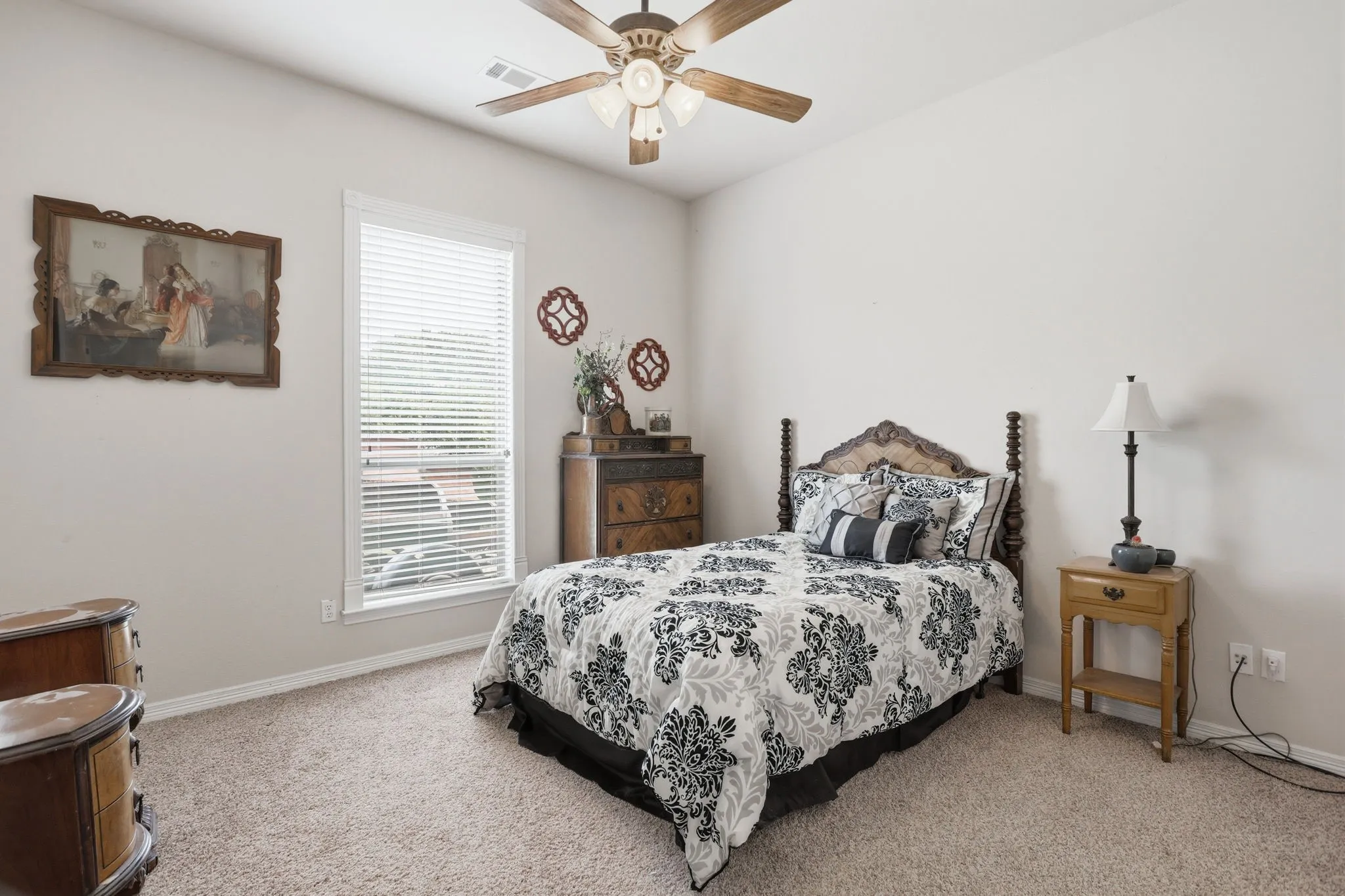 Carpeted room featuring a single window with blinds, a ceiling fan, and light-toned walls