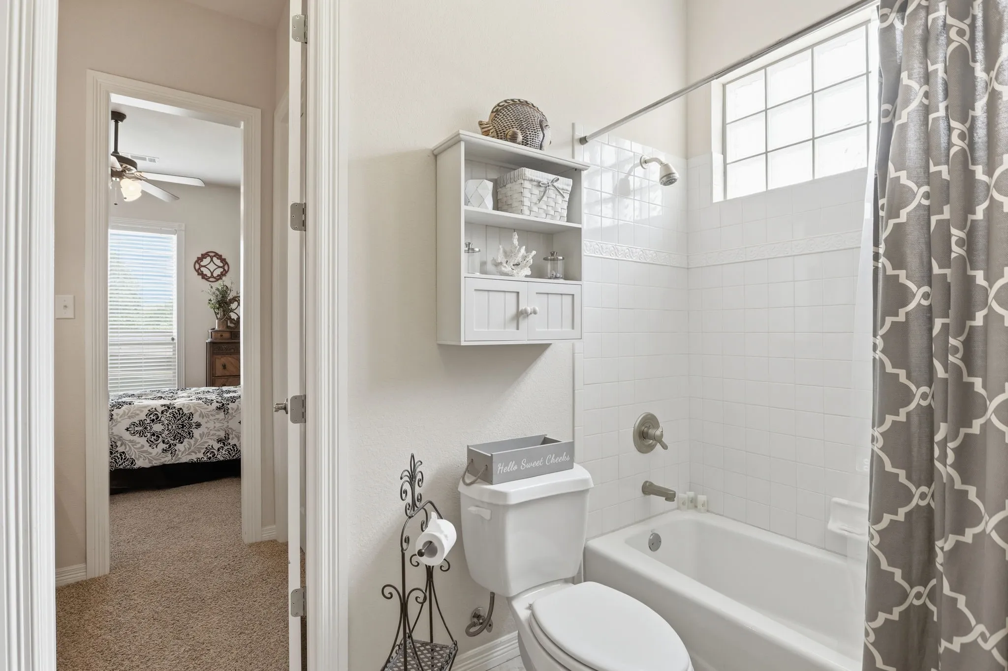Bathroom featuring a white bathtub, ceramic tile surround, and a glass block window for natural light
